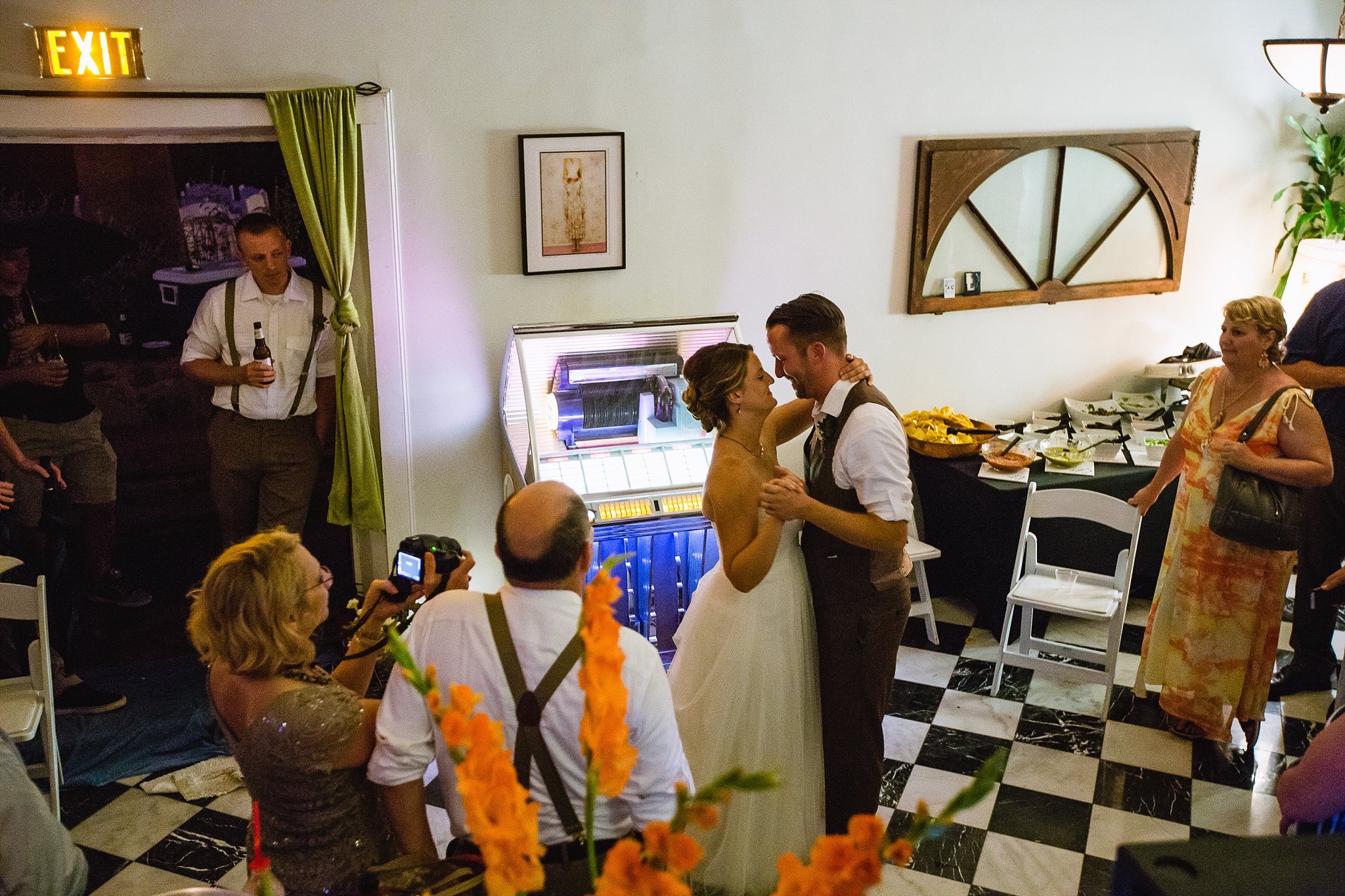 Bride and Groom share first dance in front of juke box at wedding reception by PMA Photography