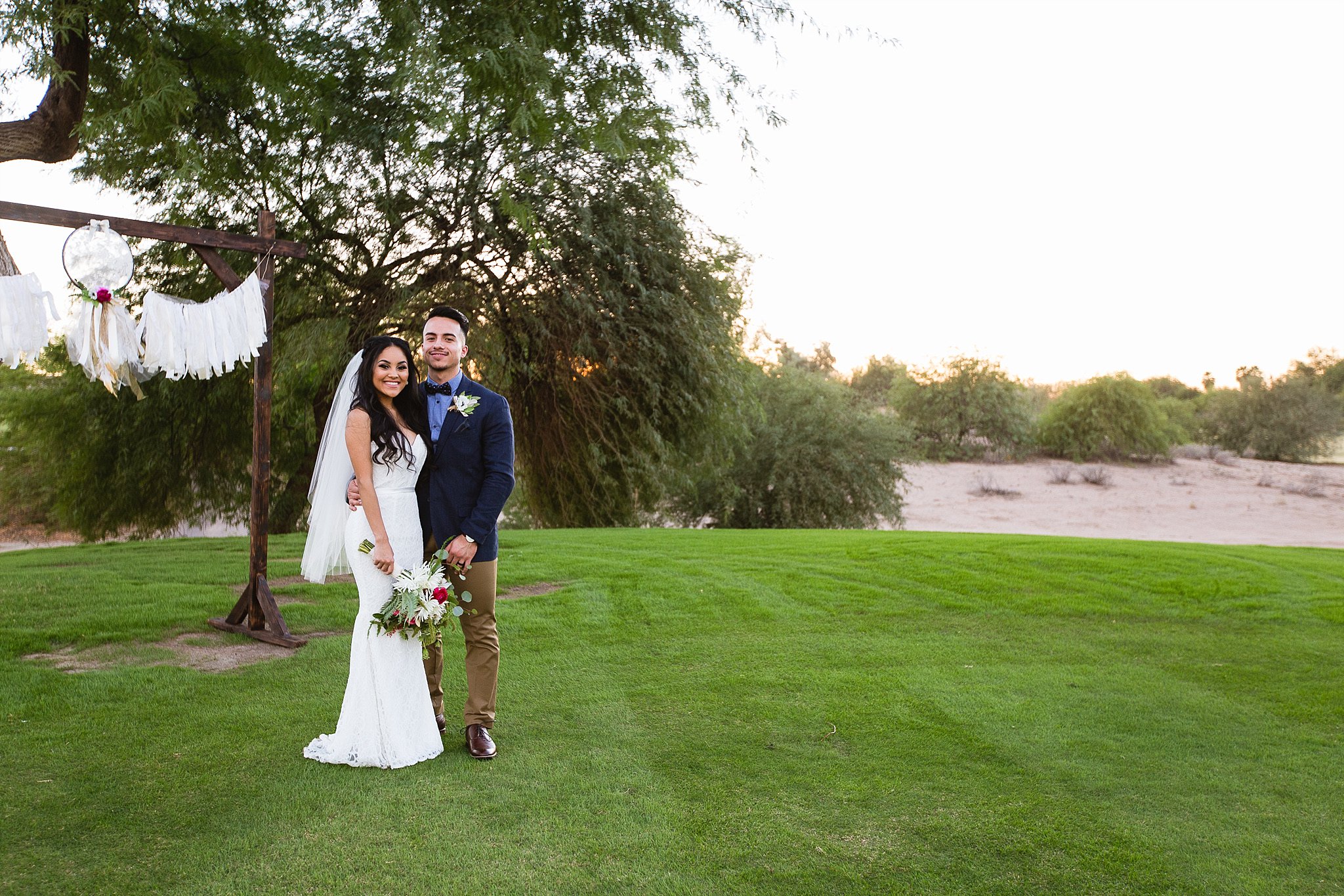 Just married bride and groom in front of their wedding altar at Legacy Golf Resort in Phoenix, Arizona by PMA Photography