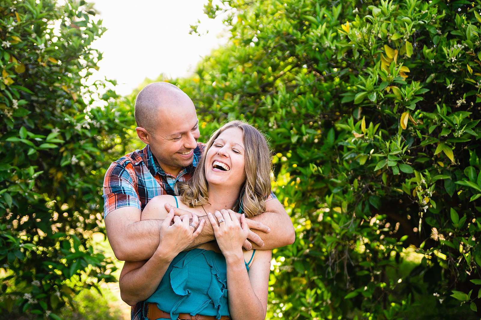 Couple laughing together during their engagement session by Phoenix engagement photographer PMA Photography.