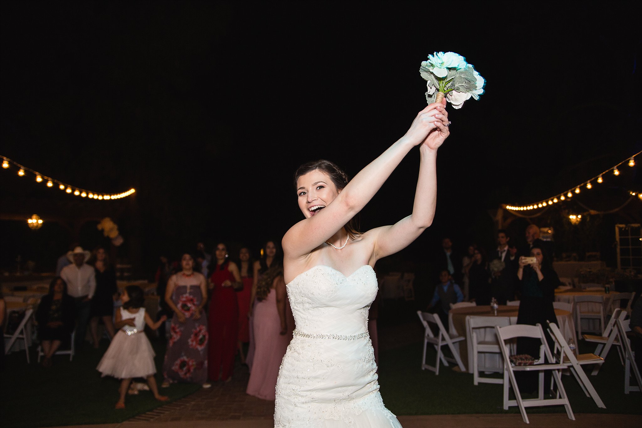 Bouquet toss at Schnepf Farms wedding reception by Queen Creek wedding photographer PMA Photography.