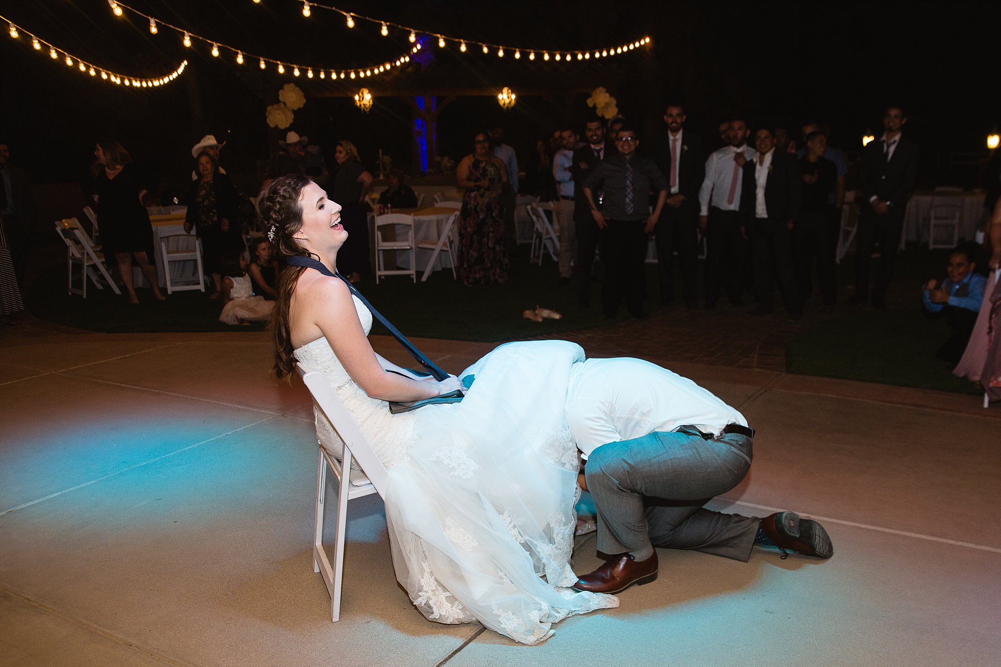 Garter toss at Schnepf Farms wedding reception by Queen Creek wedding photographer PMA Photography.