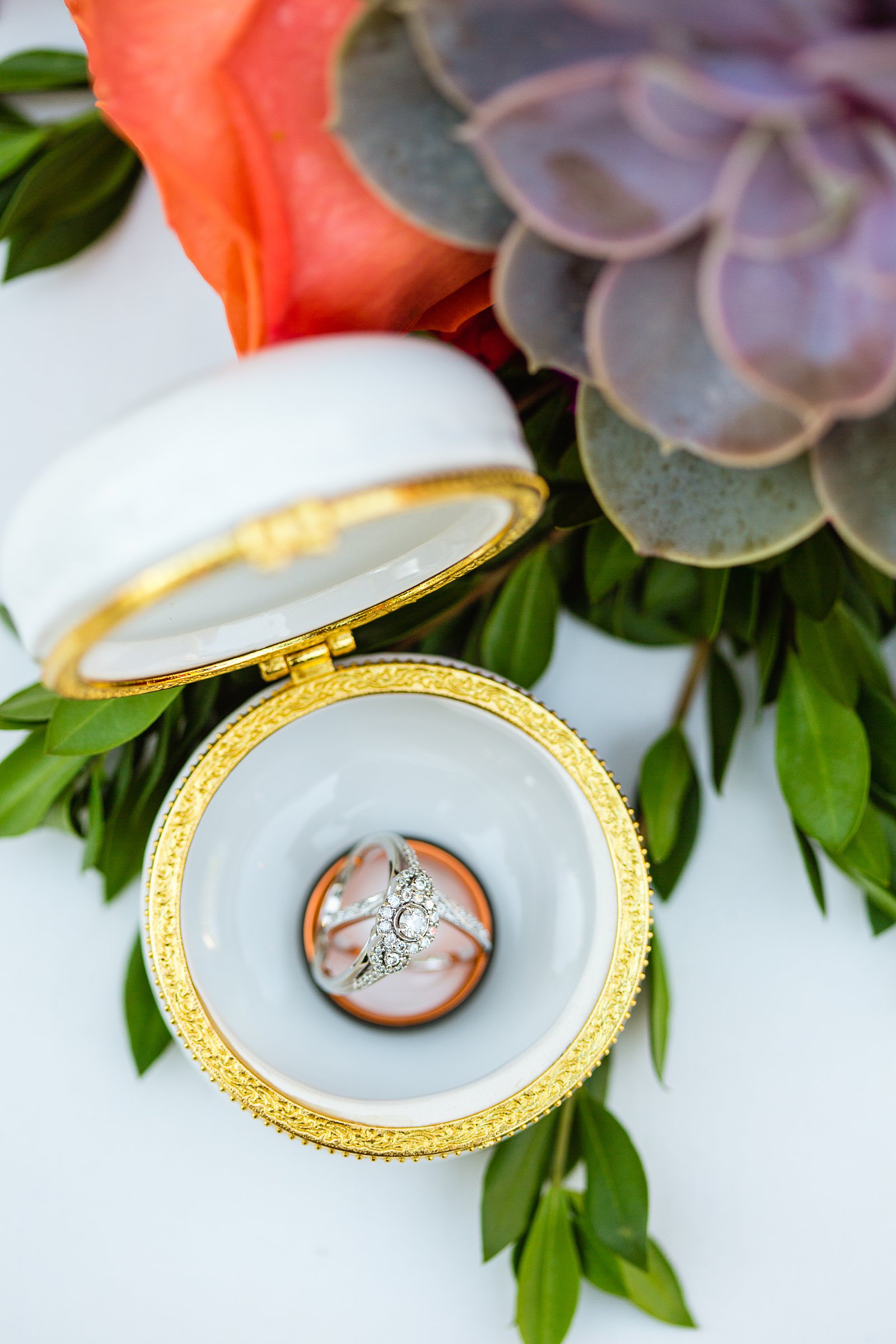 Wedding bands and engagement ring in a macaroon ring holder by PMA Photography.