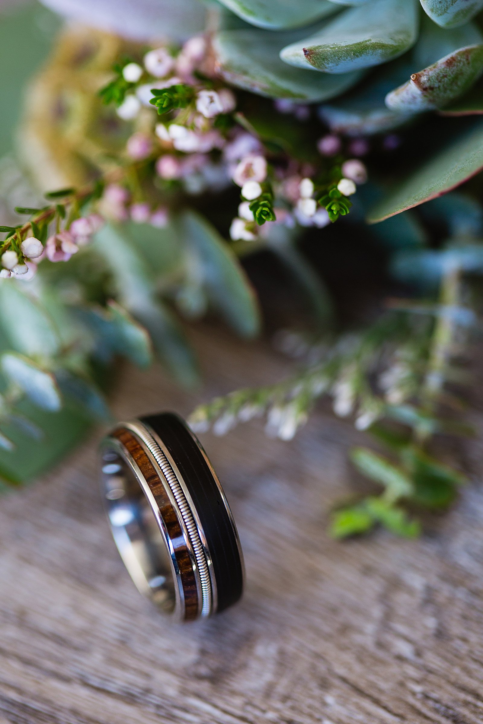 Detail shot of a unique wedding ring with a boutonniere by PMA Photography.