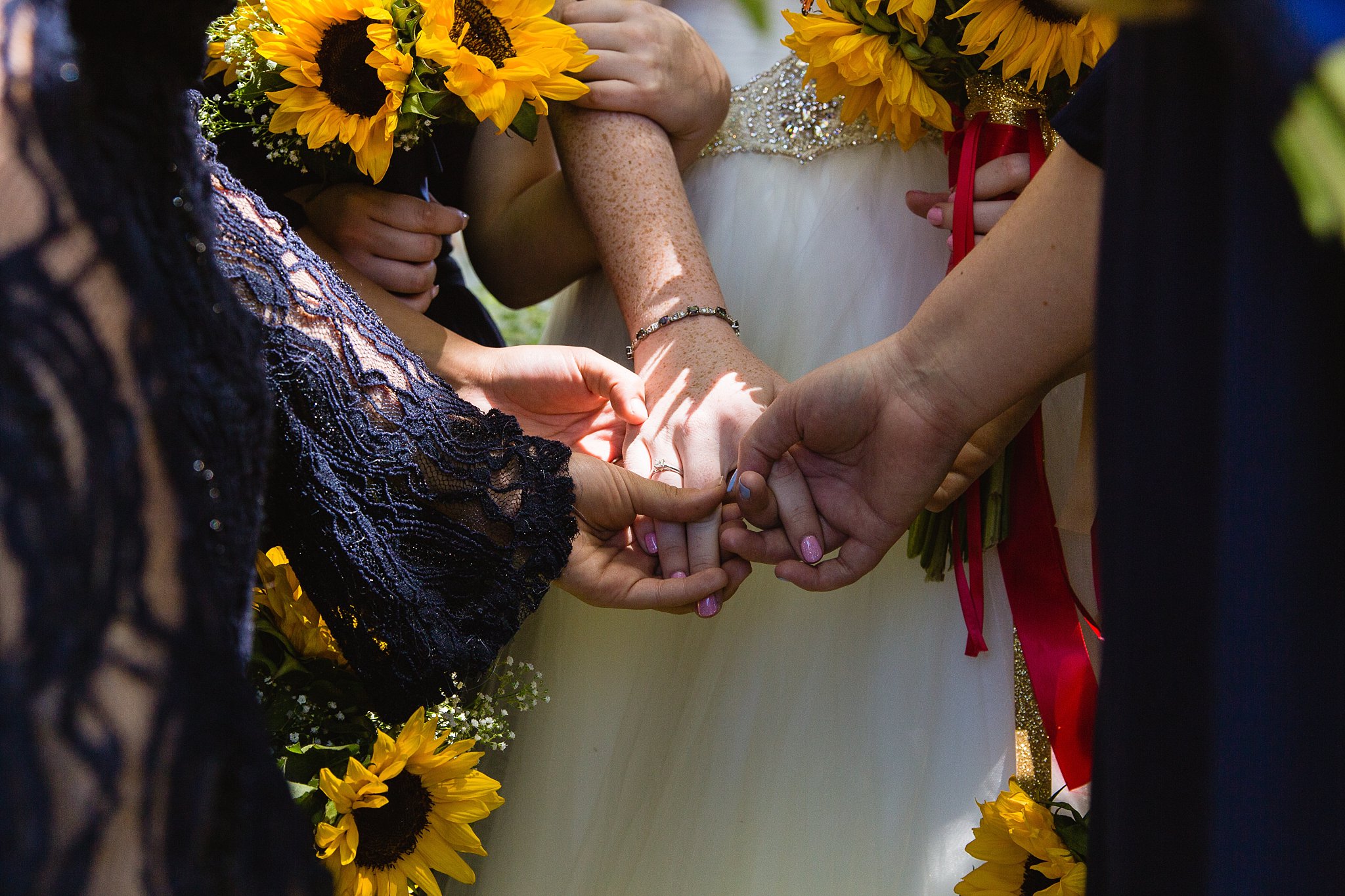 Bride and bridesmaids praying together at Sky Ranch Lodge wedding by Sedona wedding photographer PMA Photography.