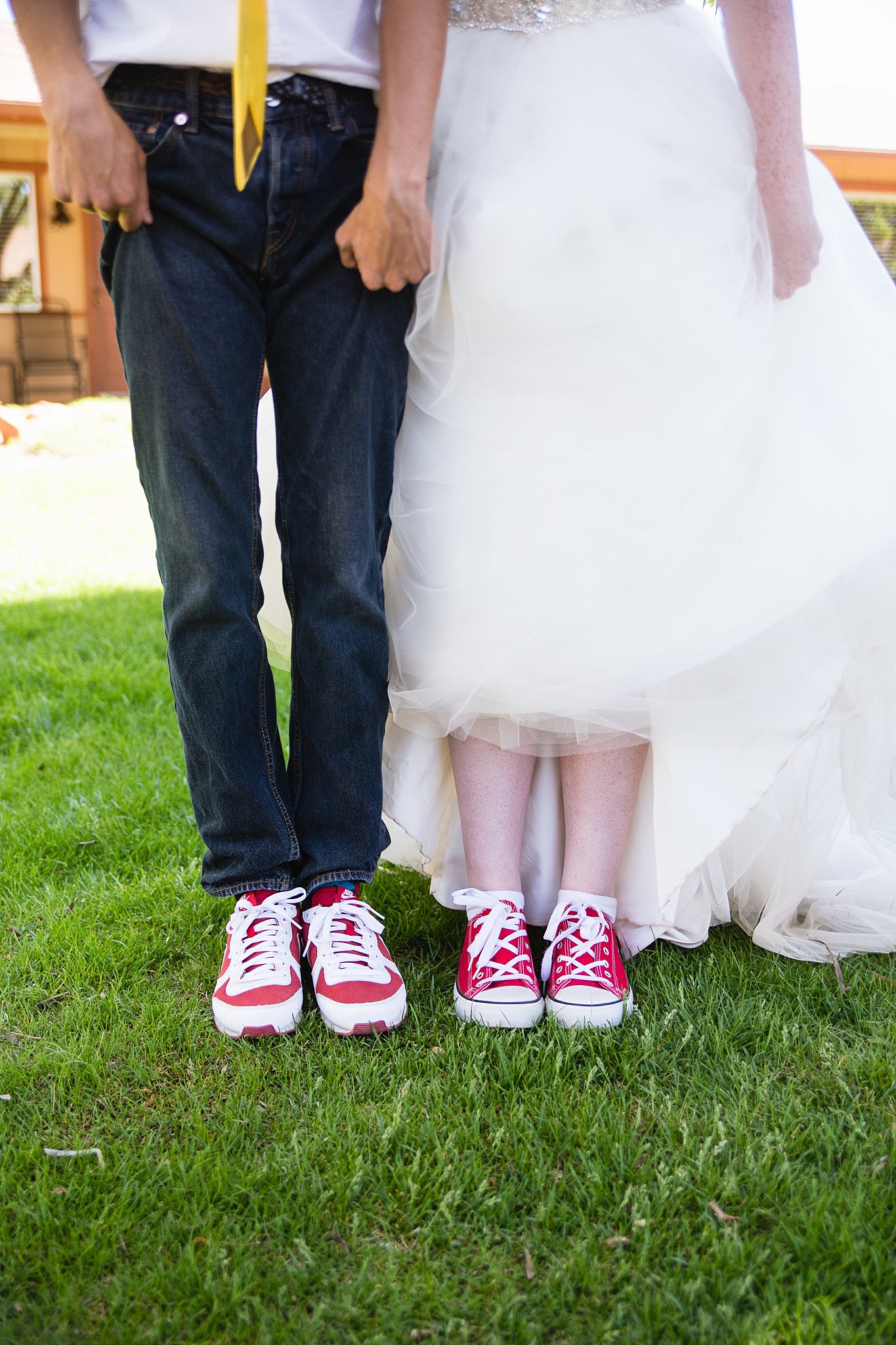 Bride and groom show off their red wedding day sneakers by PMA Photography.