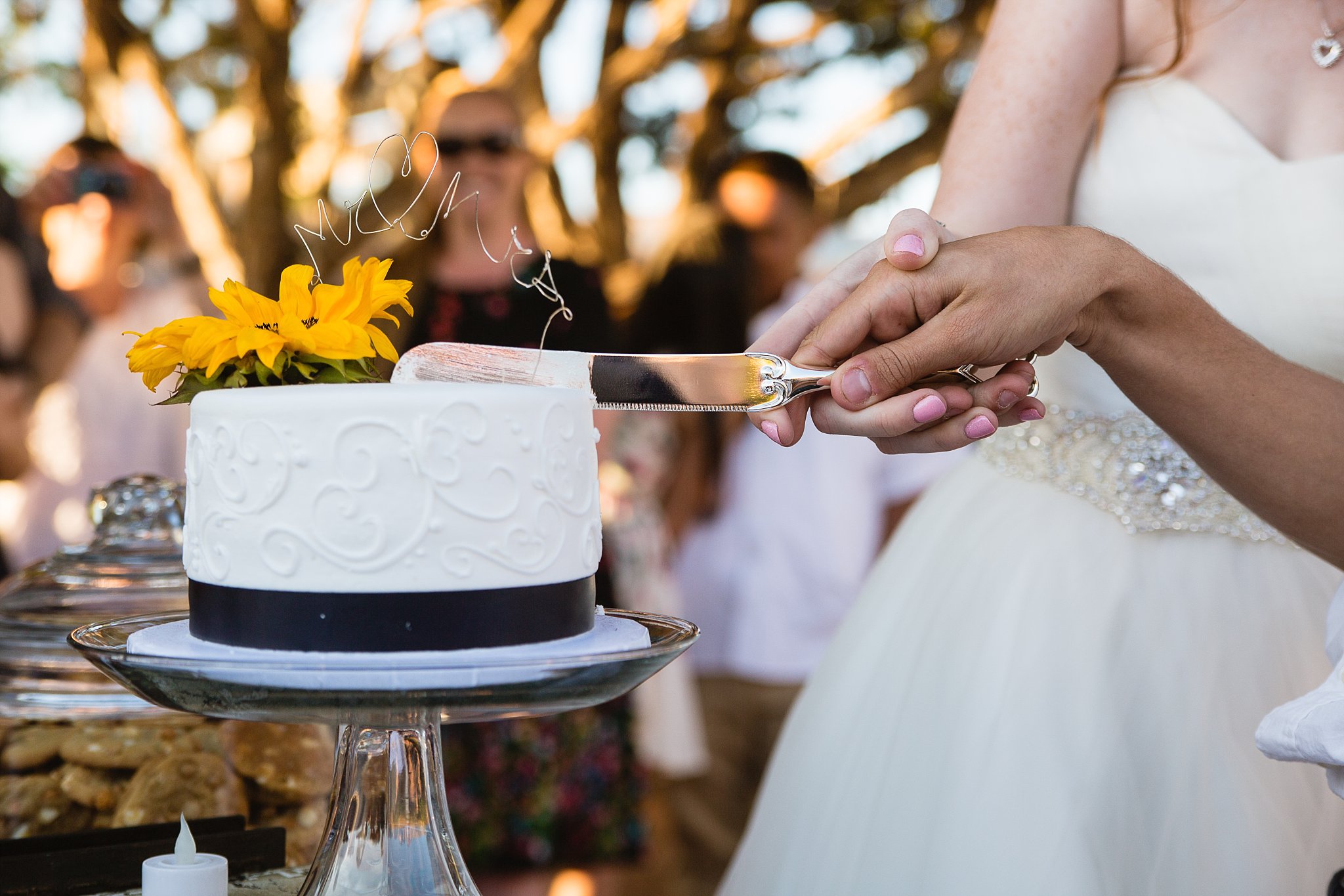 Bride and groom cutting their wedding cake at their Sky Ranch Lodge wedding reception by Arizona wedding photographer PMA Photography.