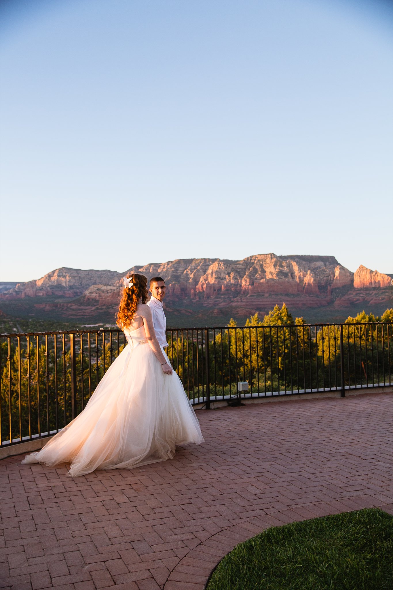 Bride and groom walking together during their Sky Ranch Lodge wedding by Sedona engagement photographer PMA Photography.