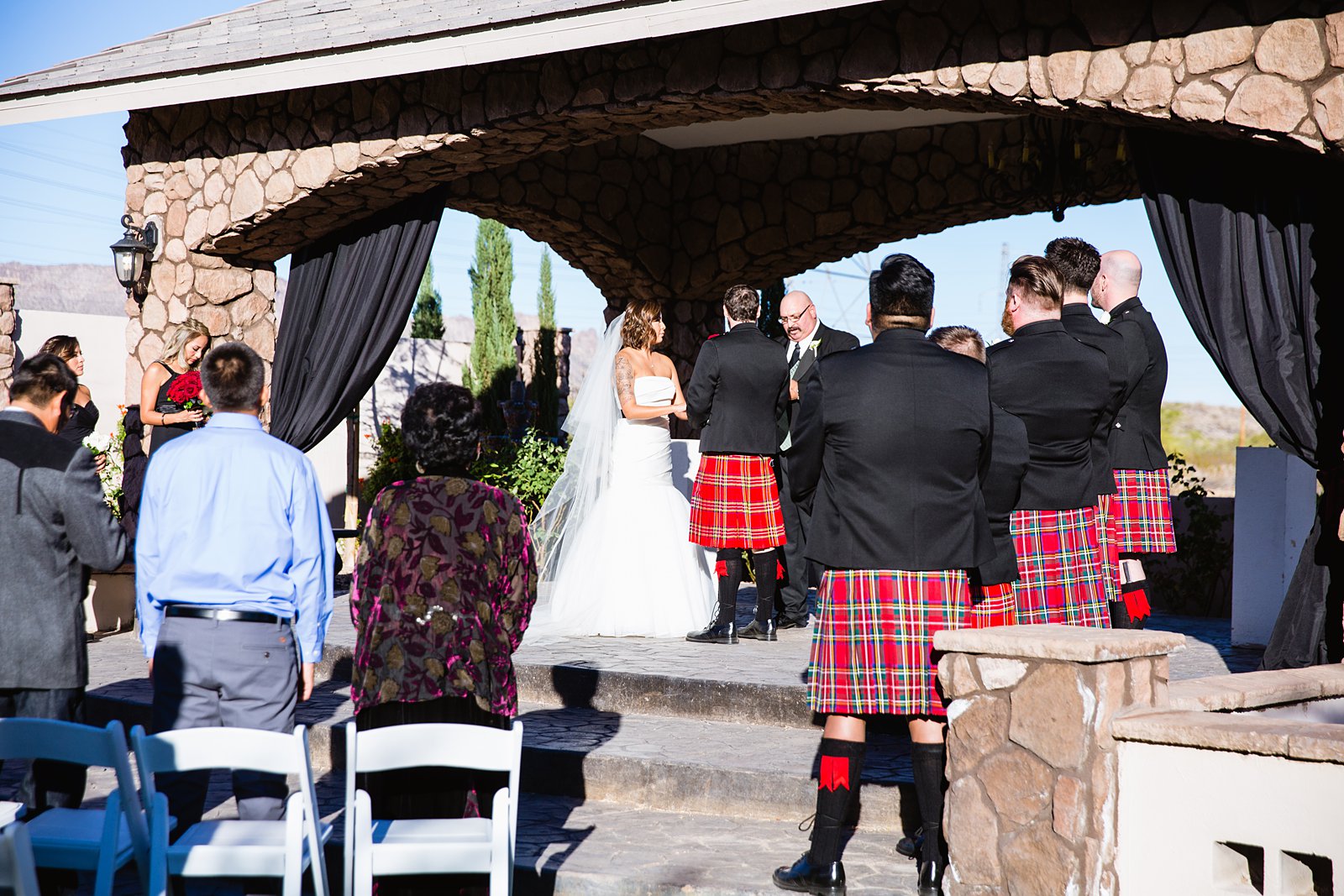 Kilted groomsmen watch the wedding ceremony by Arizona wedding photographers PMA Photography.