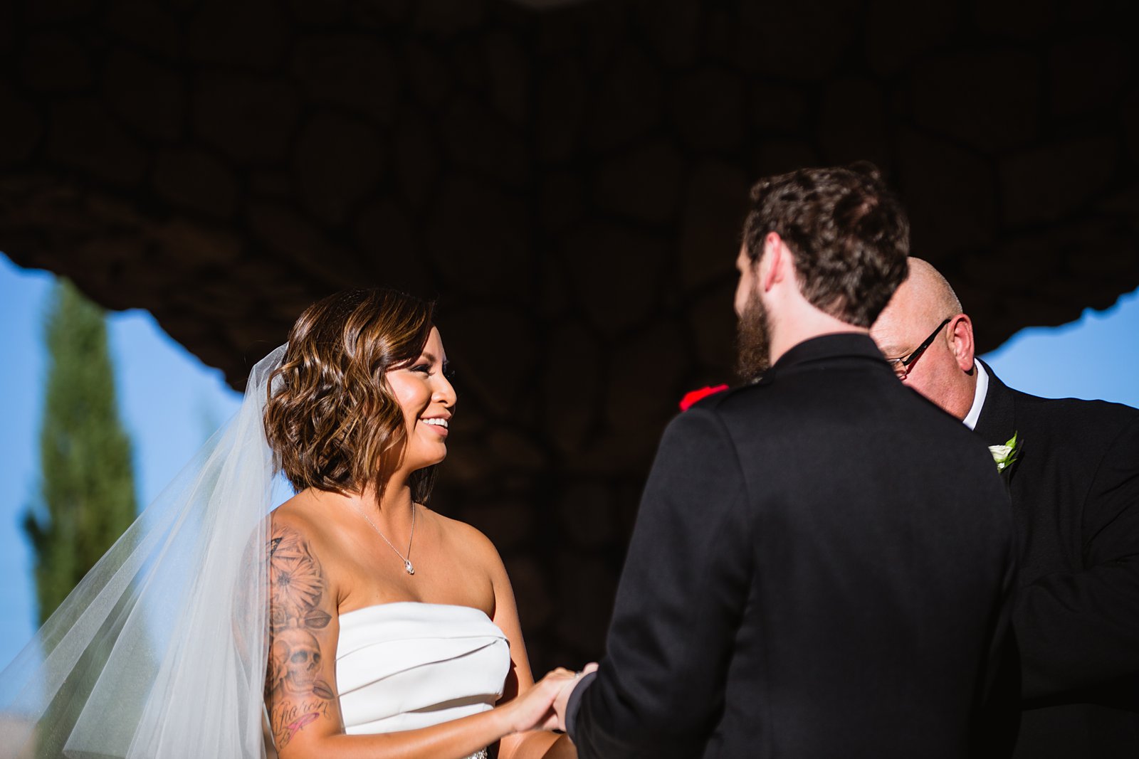 Bride smiling during the wedding ceremony by Mesa wedding photographers PMA Photography.