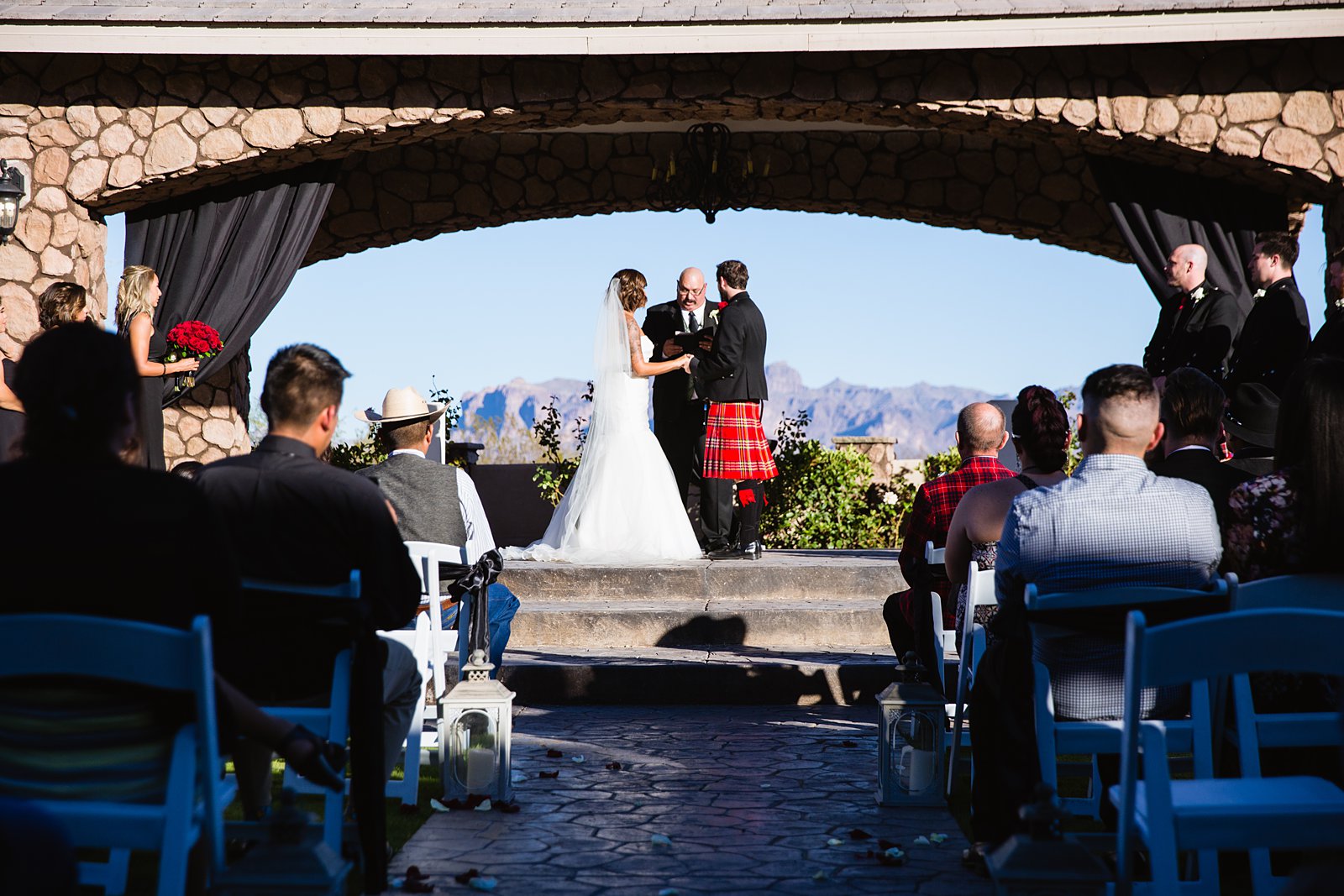 Bride and groom at the ceremony altar with the views of the Superstition Mountains at Superstition Manor by Mesa wedding photographers PMA Photography.
