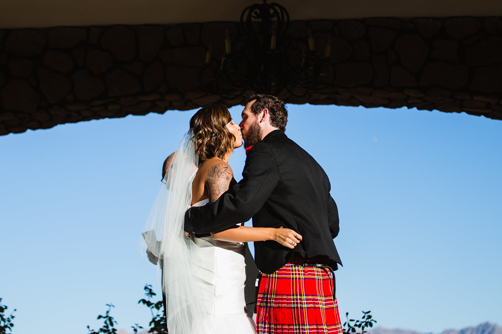 Bride and groom share their first kiss by PMA Photography.