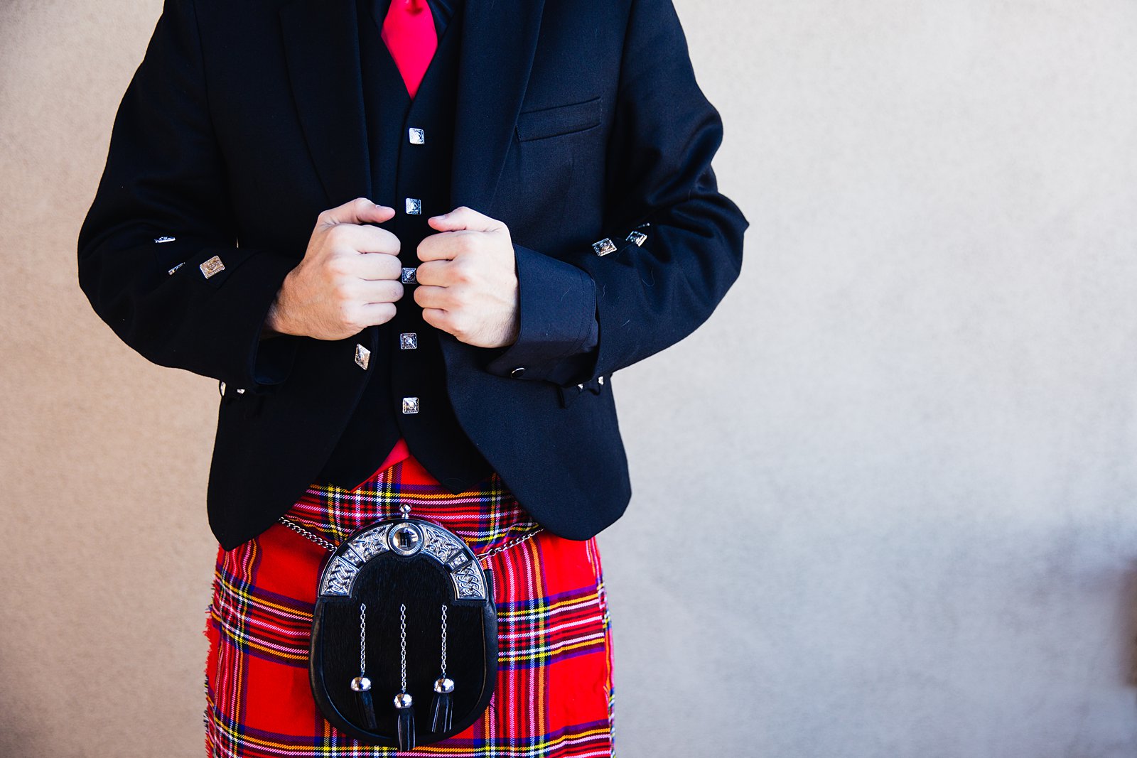 Details of groom's red and black formal wedding kilt outfit by Arizona wedding photographer PMA Photography.