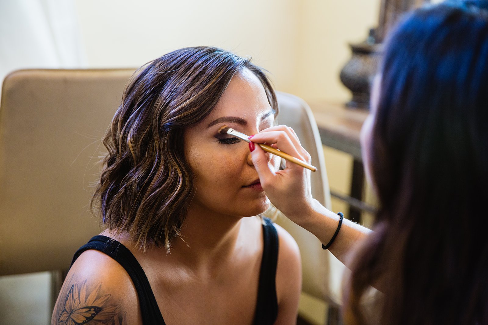 Bride getting her makeup done on her wedding day by Arizona wedding photographer PMA Photography.