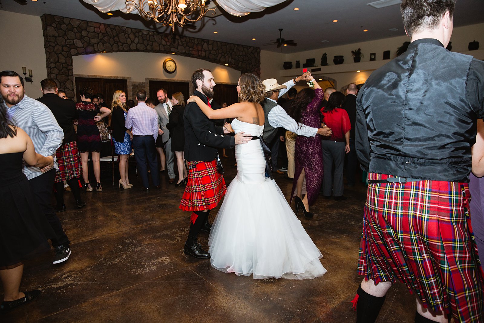 Bride and groom dancing with guests during their wedding reception at the Superstition Manor by Arizona wedding photographers PMA Photography.