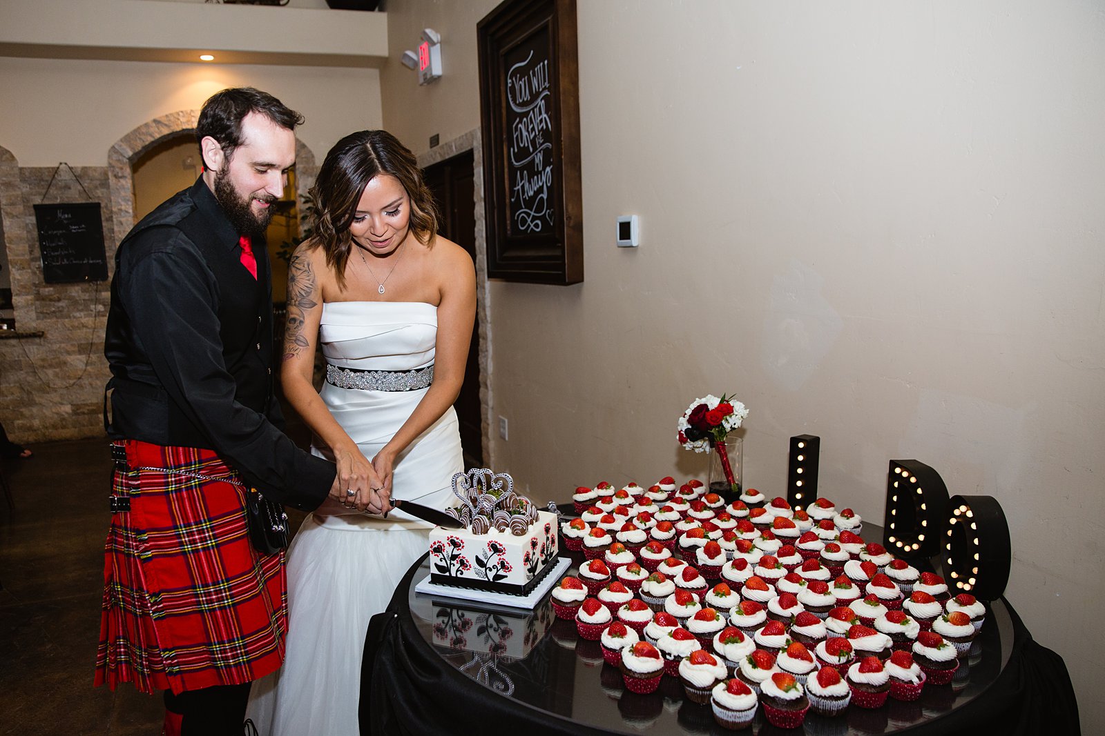 Bride and groom cutting the cake during their wedding reception at the Superstition Manor by PMA Photography.