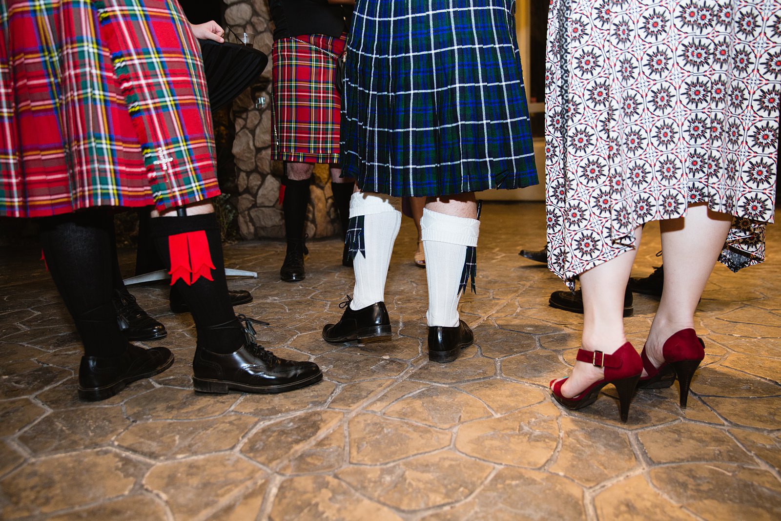 Guests in kilts at a wedding by PMA Photography.