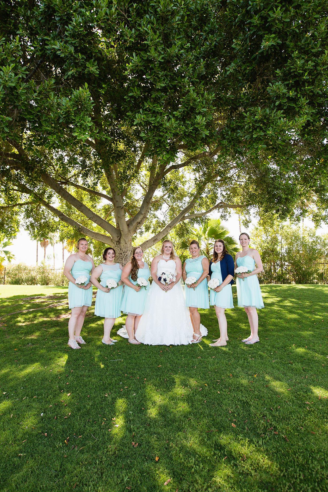 Bride and bridesmaids together at a Val Vista Lakes wedding by Arizona wedding photographer PMA Photography.