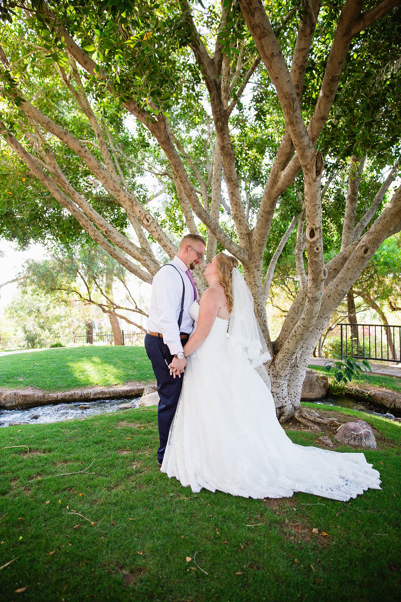 Bride and groom share an intimate moment at their Val Vista Lakes wedding by Arizona engagement photographer PMA Photography.