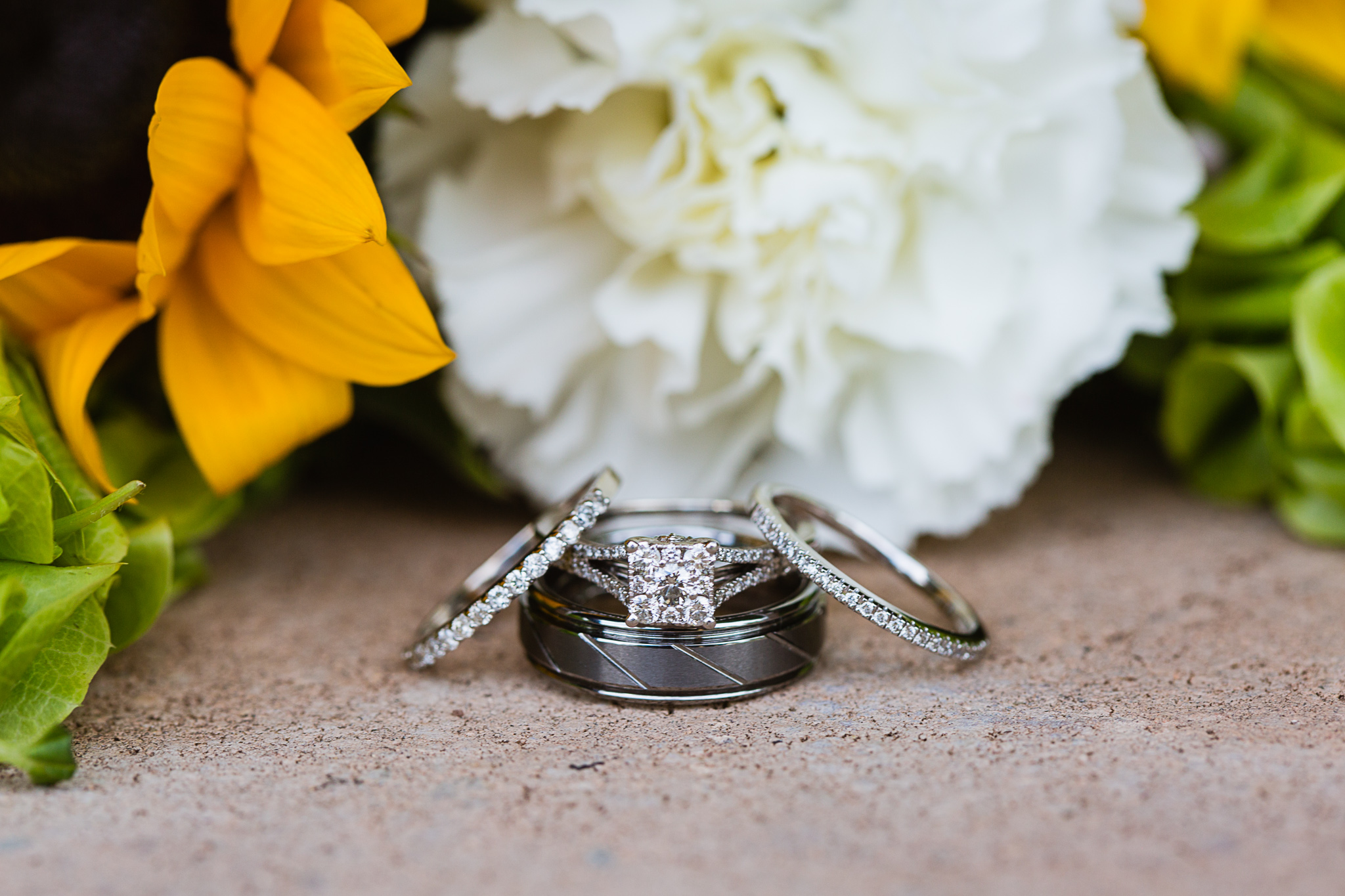 Detail image of wedding rings in front of bouquet at backyard garden wedding by Phoenix wedding photographer PMA Photography.