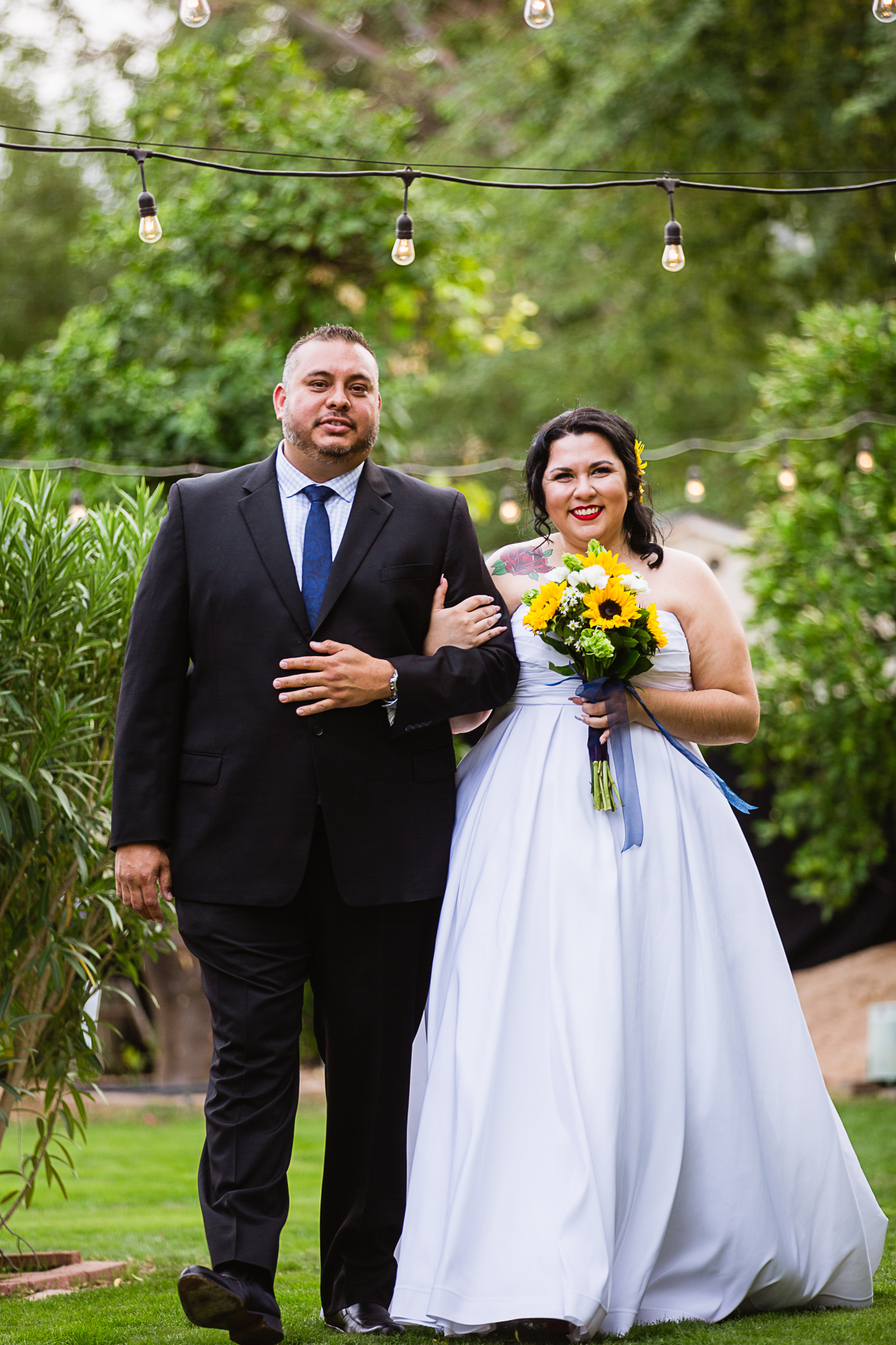 Bride walking down the aisle with her uncle at her backyard garden wedding ceremony by Phoenix wedding photographer PMA Photography.