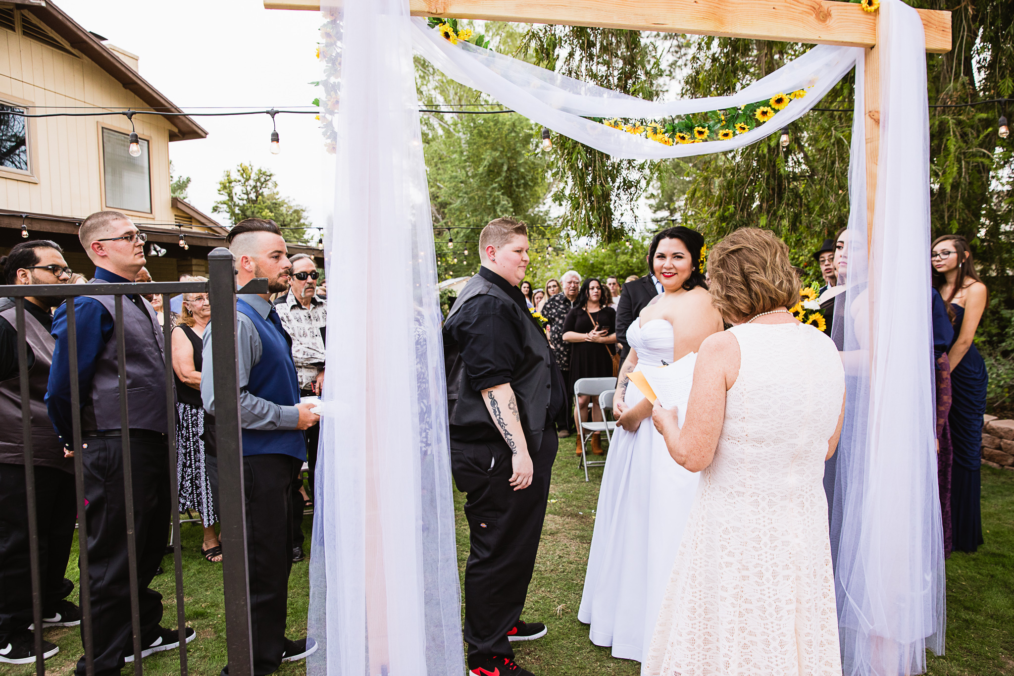 Brides during same sex backyard garden ceremony by Phoenix wedding photographer PMA Photography.