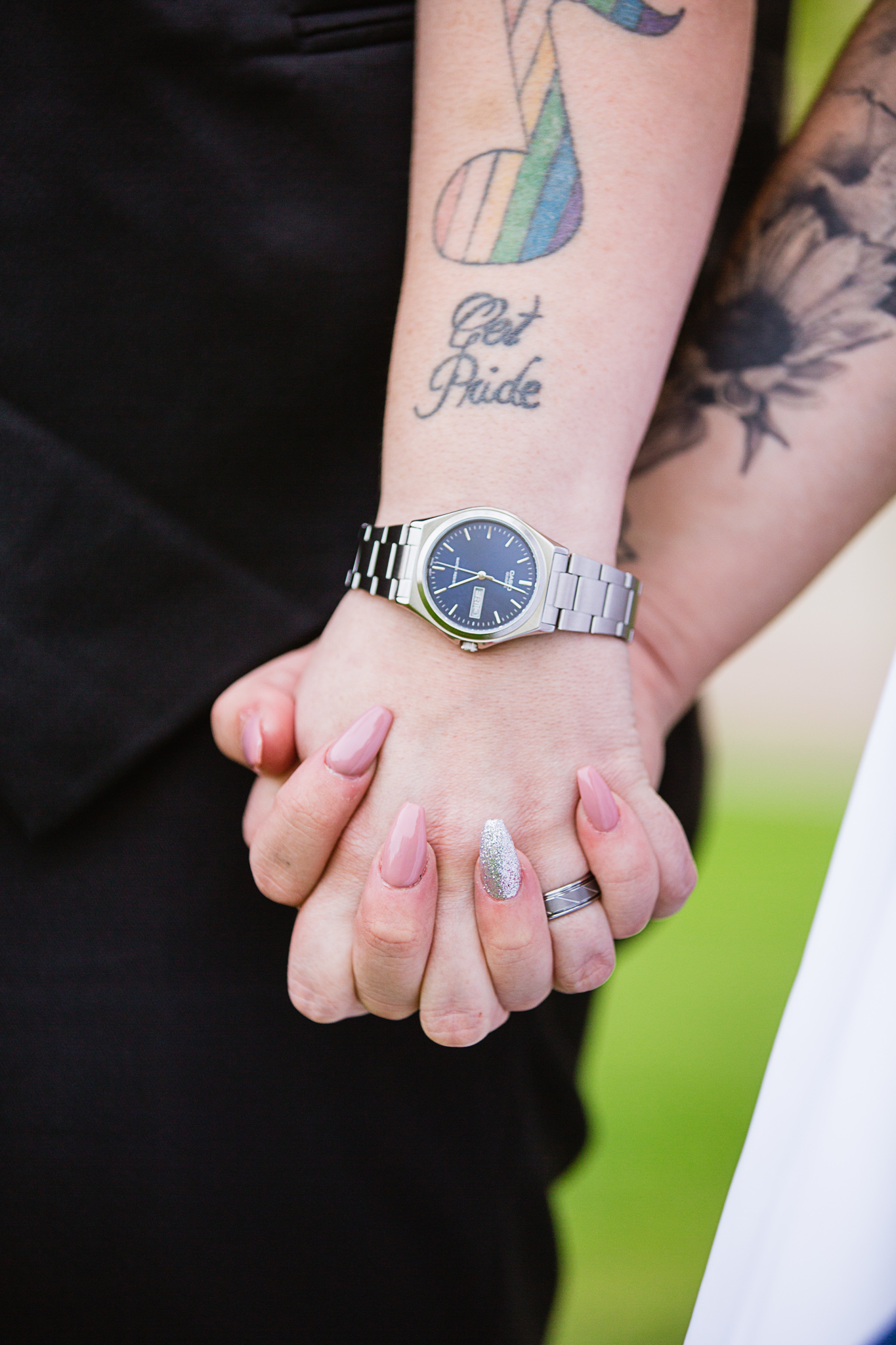 Close up image of LGBT couple holding hands showing 'got pride'tattoo by wedding photographer PMA Photography.