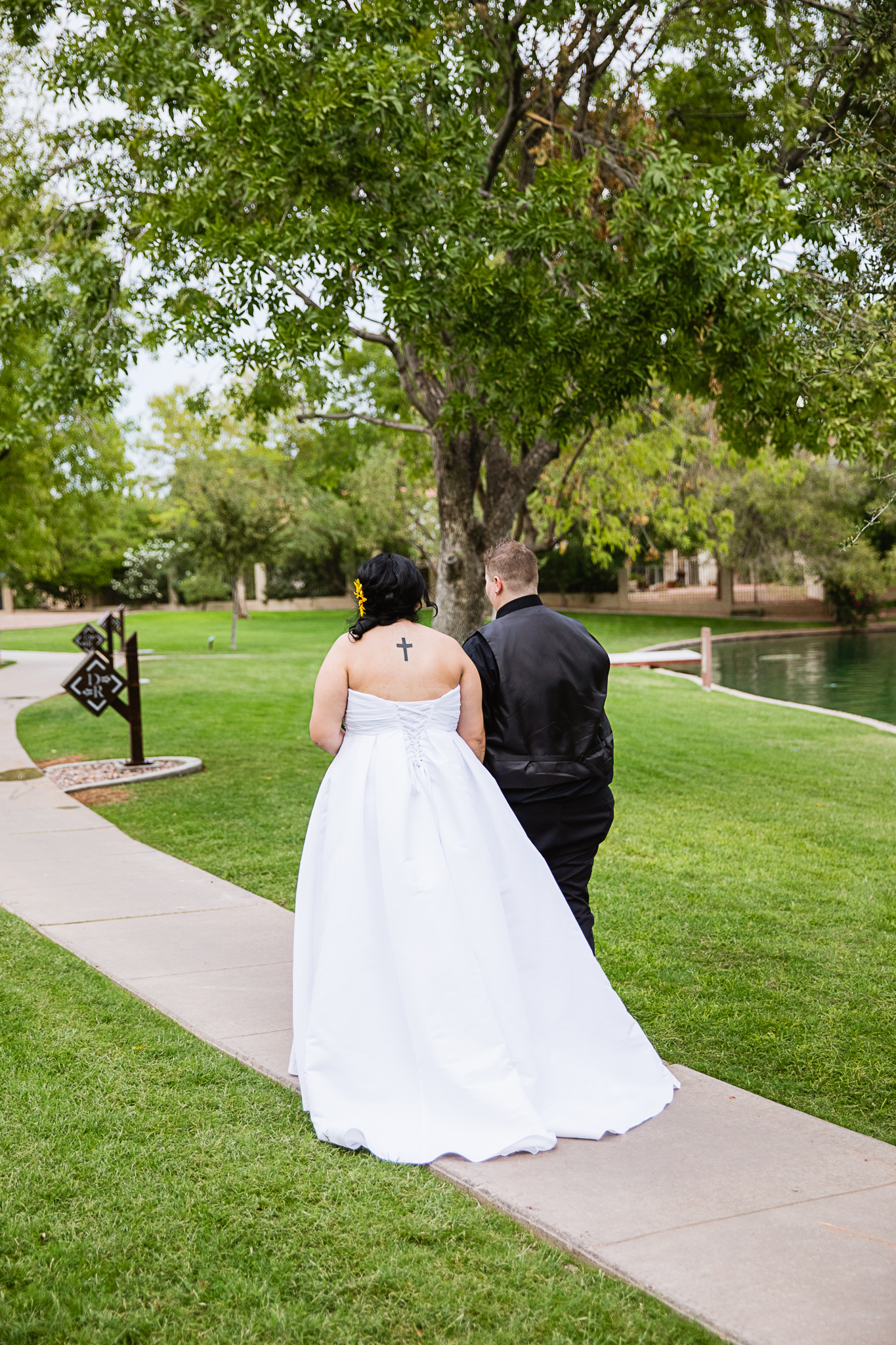 LGBT couple walking down a path in a park on their wedding day by Phoenix wedding photographers PMA Photography.