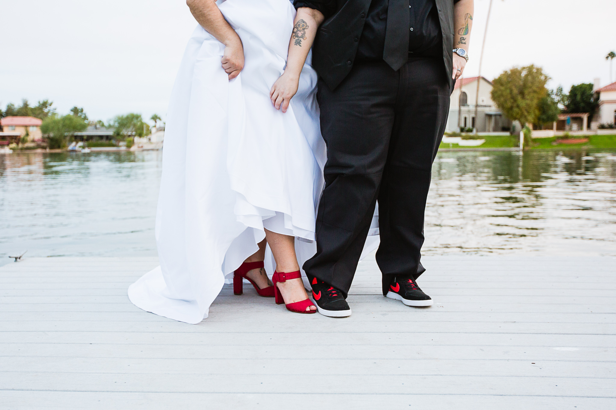 LGBT brides showing off the complimentary red wedding shoes.