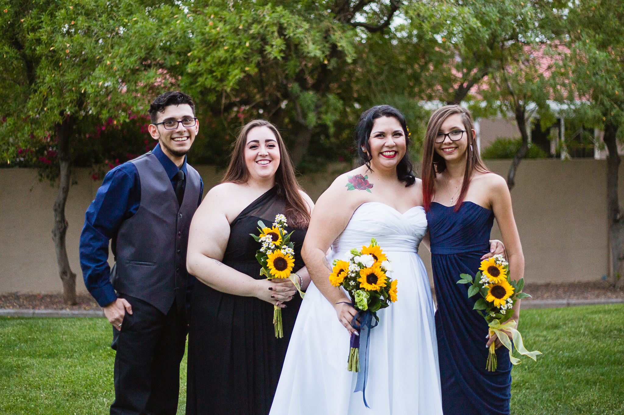 Bride with her mixed gender bridal party in black and navy outfits.