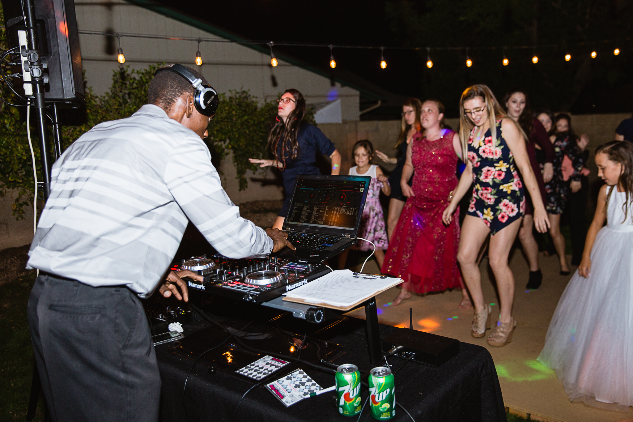 Guests dancing at backyard garden wedding in front of DJ booth.