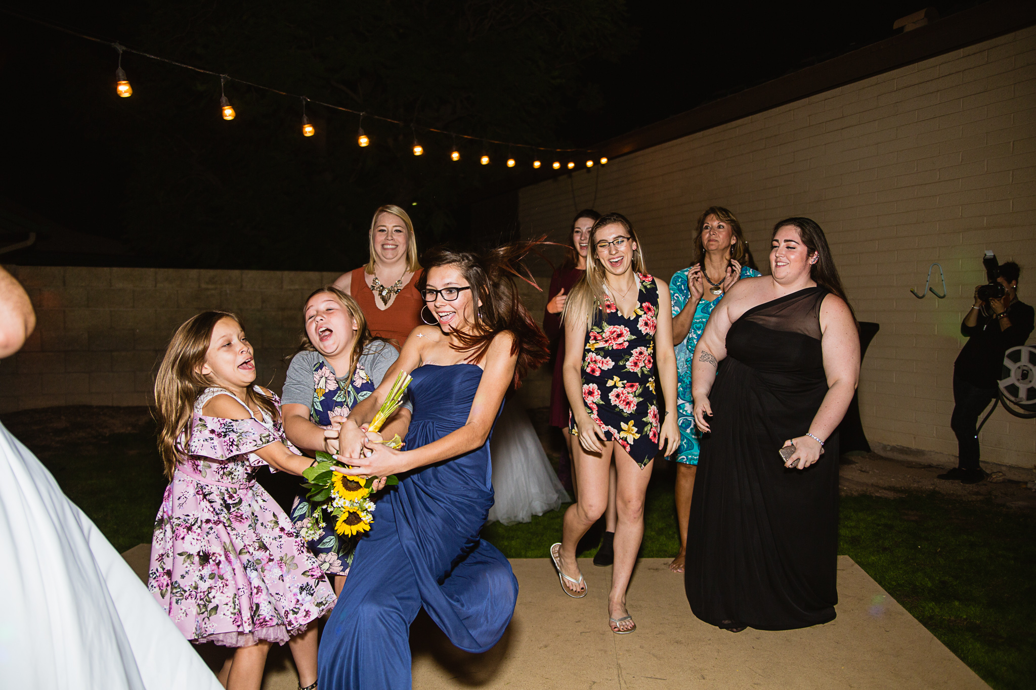 Guests catching the bouquet at a wedding reception.