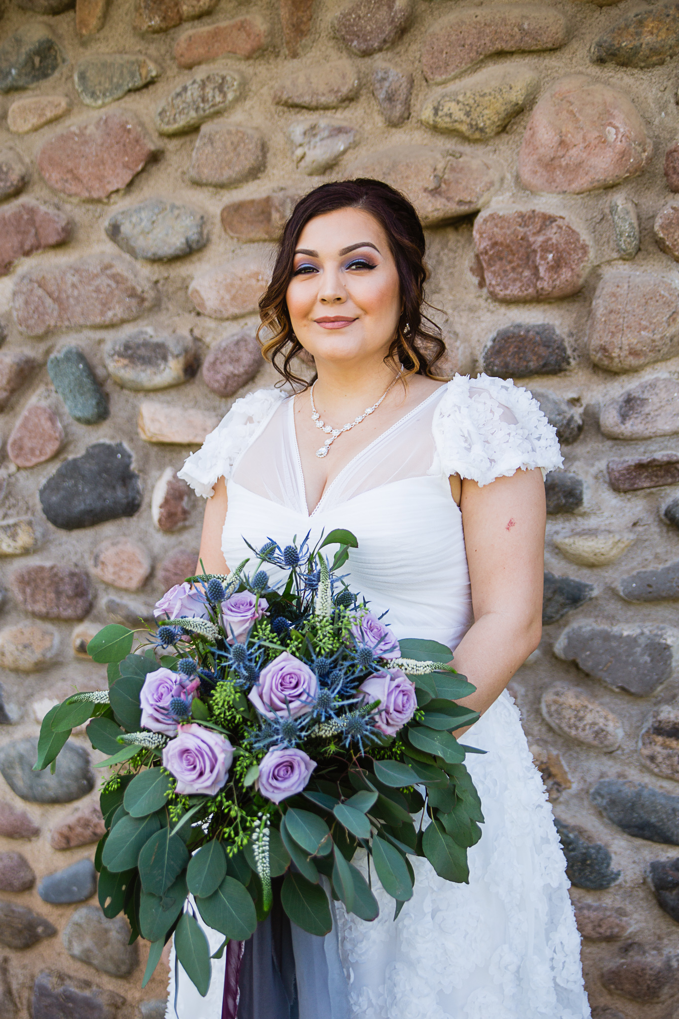 Bride on her wedding day with wild dusty blue and lavender wedding bouquet by Arizona wedding photographer PMA Photography.