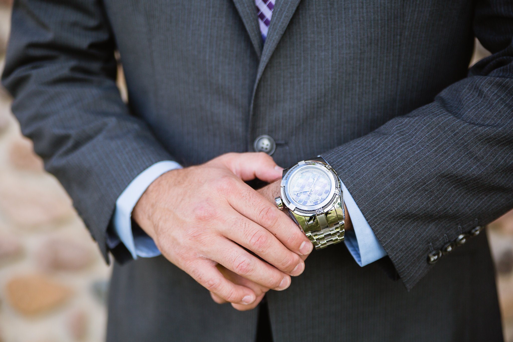 Groom adjusting his watch while getting ready for his wedding day by Arizona wedding photographers PMA Photography.