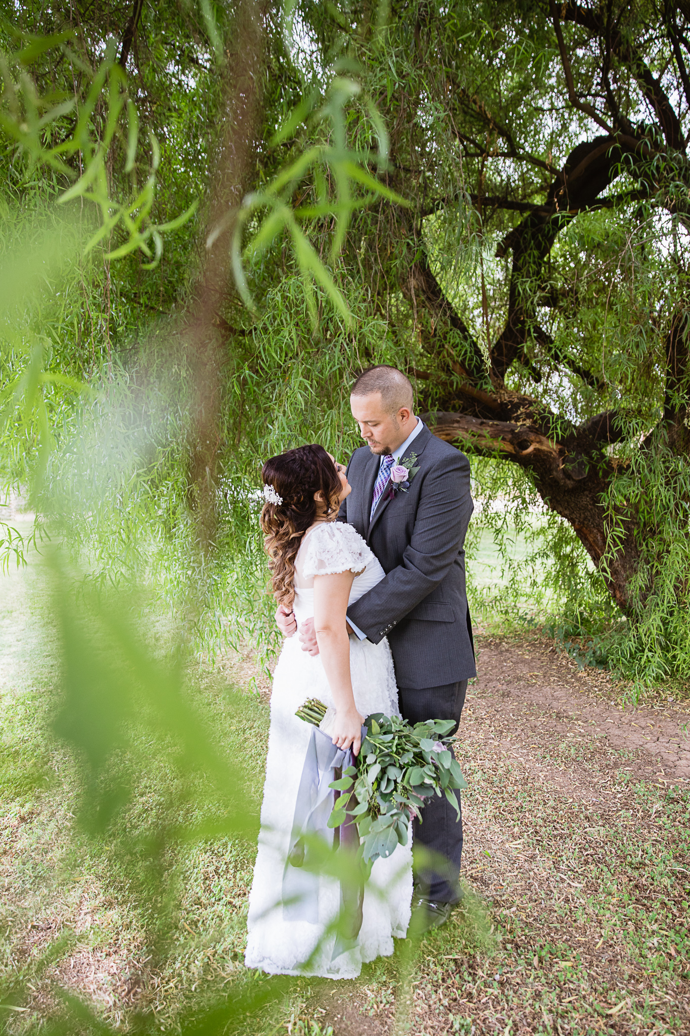 Bride and groom share an intimate moment entwined in a tree by Phoenix wedding photographer PMA Photography.
