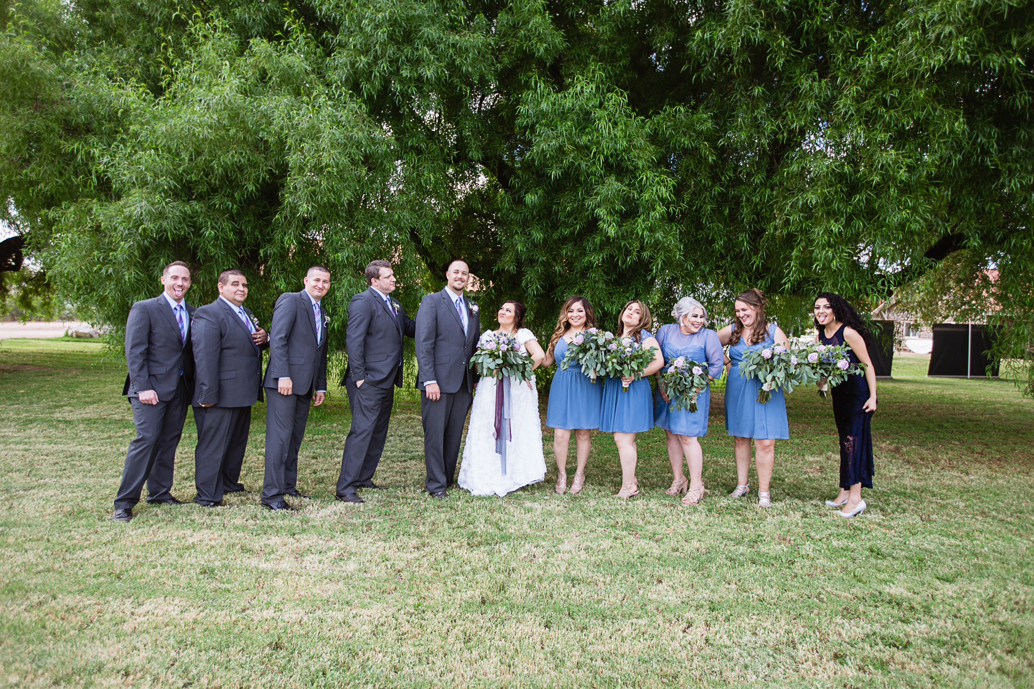 Dusty blue and lavender bridal party pose as if they are in a photobooth by PMA Photography.