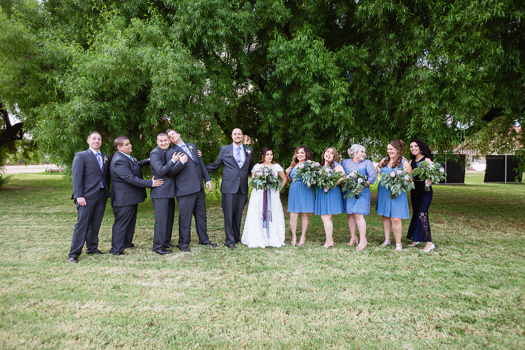Dusty blue and lavender bridal party act as if they are in a photobooth by PMA Photography.