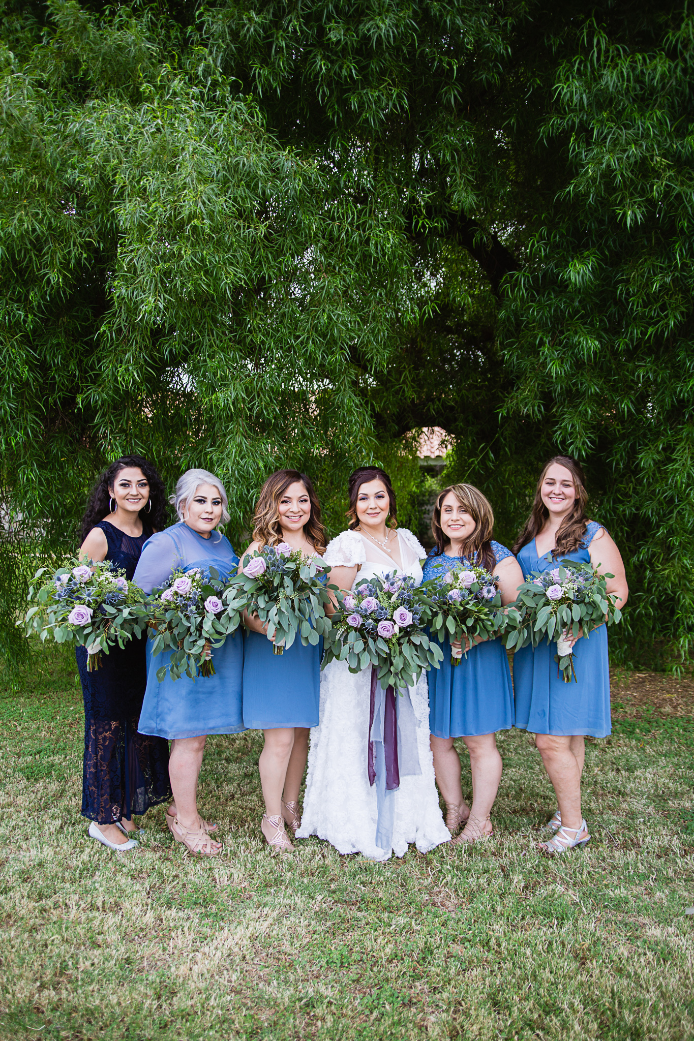 Bride with her bridesmaids and flower girl in dusty blue and navy by Arizona wedding photographers PMA Photography.