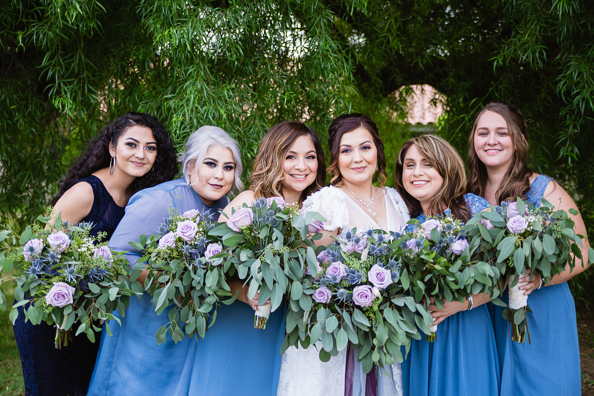 Bride with her bridesmaids and flower girl in dusty blue and navy by Arizona wedding photographers PMA Photography.