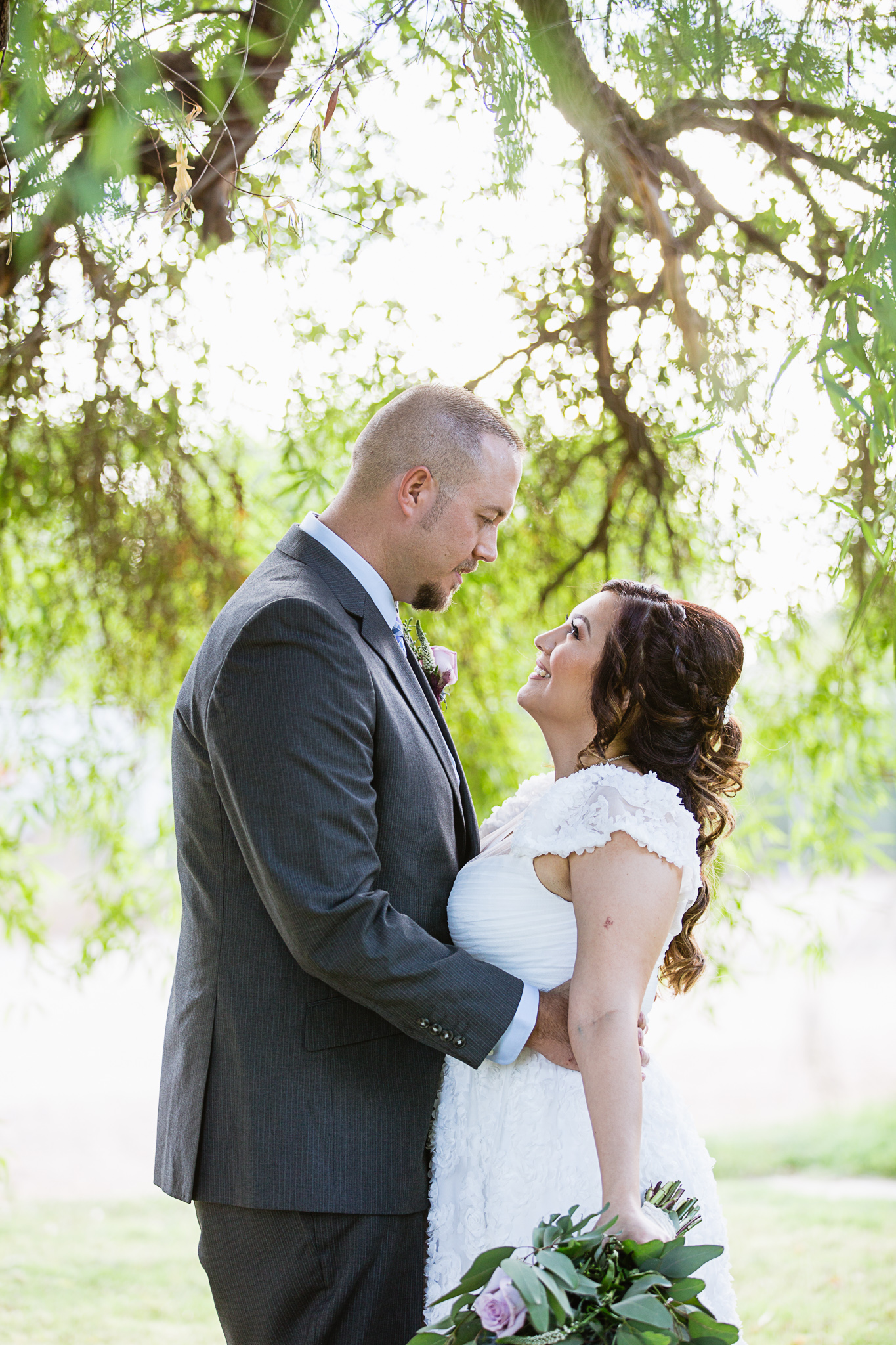 Bride and groom look at each other on their wedding day by PMA Photography