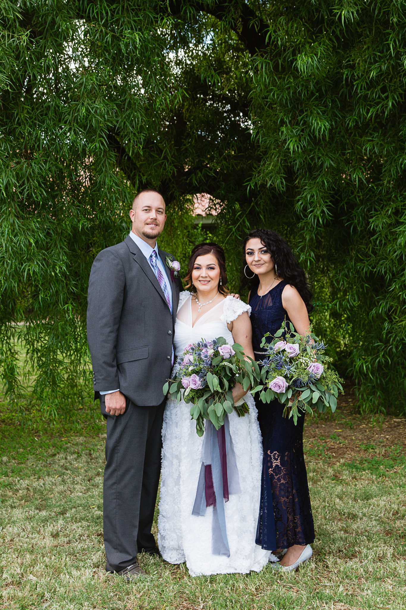 Bride and groom with their daughter on their wedding day by PMA Photography.