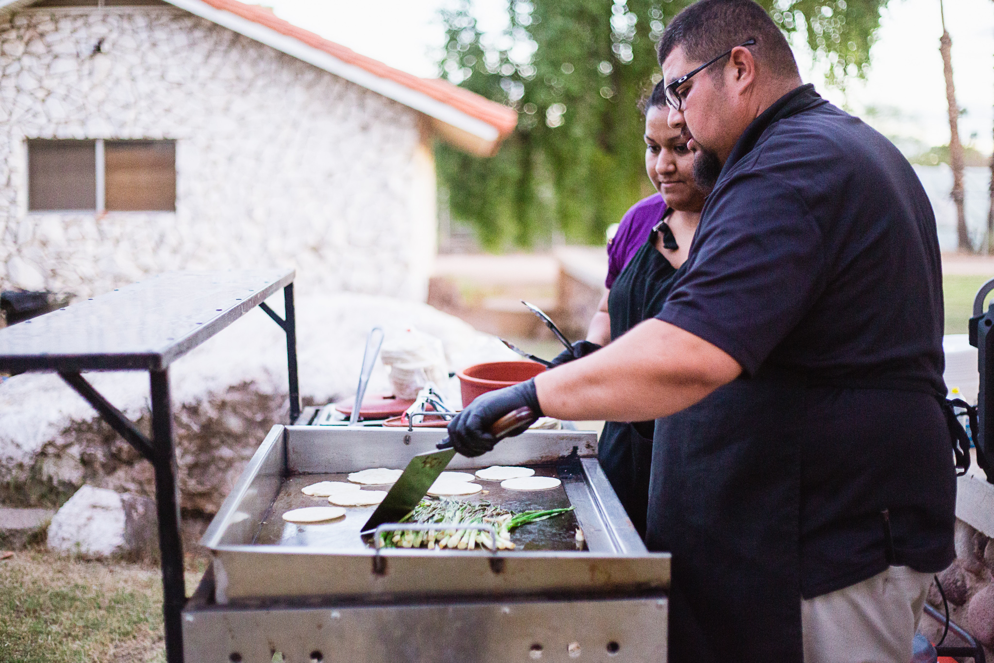 Tacos being prepared at a wedding reception by PMA Photography.