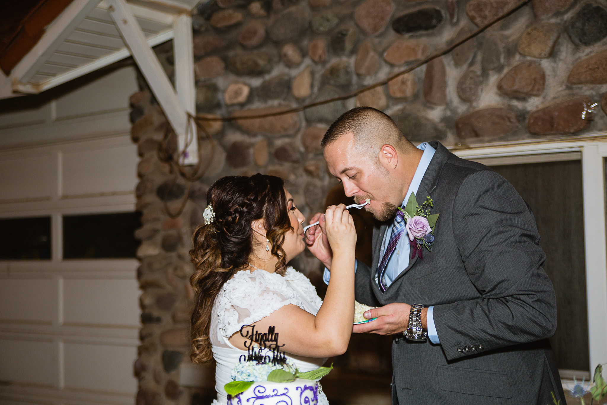 Bride and groom cut the cake at their wedding reception by PMA Photography.