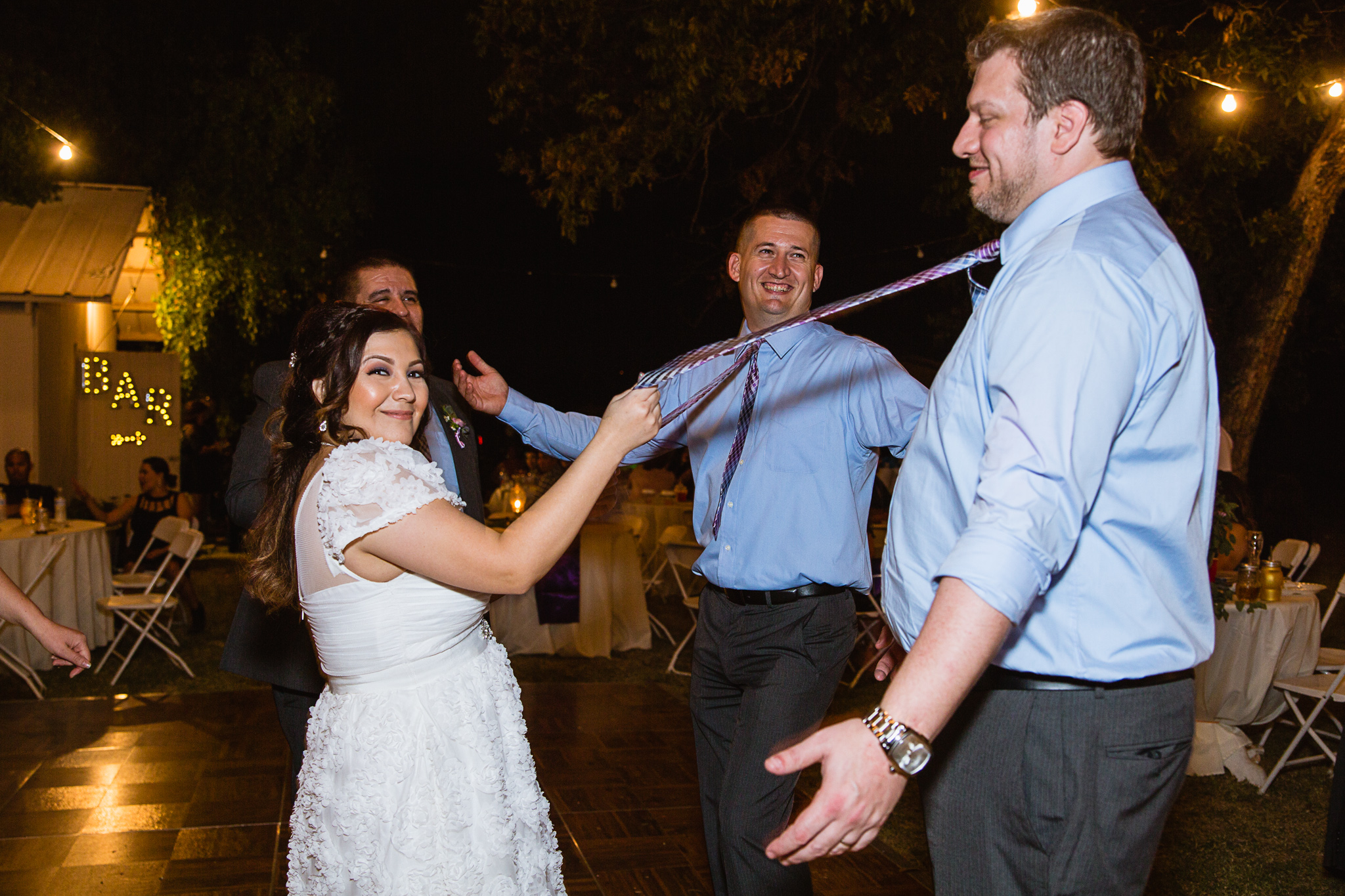 Bride dancing with groomsmen at wedding reception by PMA Photography.
