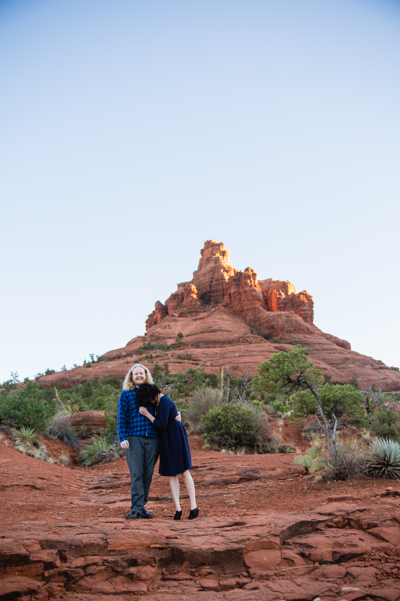 Couple laughing during engagement session at Bell Rock in Sedona Arizona by engagement photographer PMA Photography.