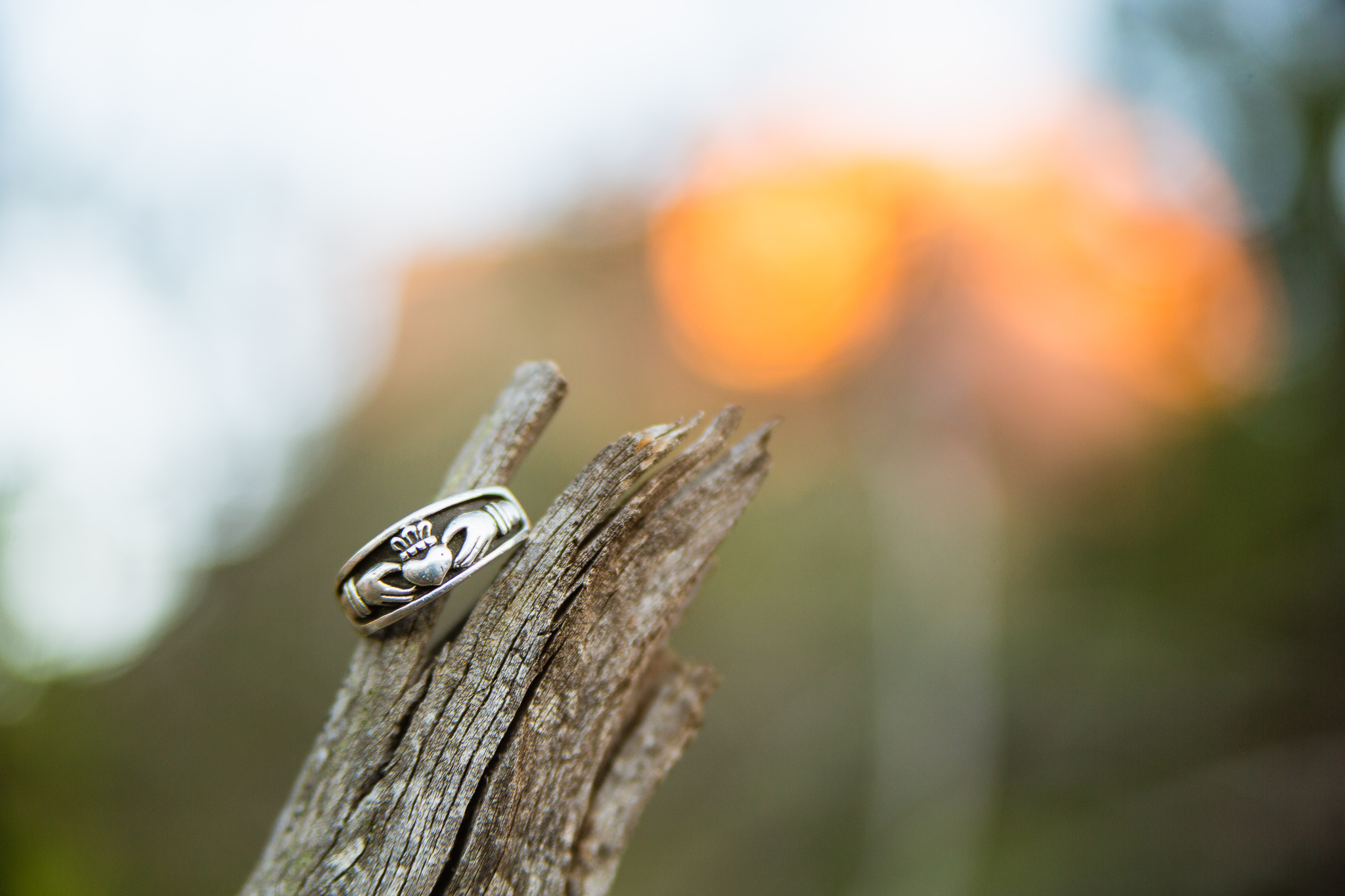 Claddagh engagement ring for him on a piece of wood by PMA Photography.