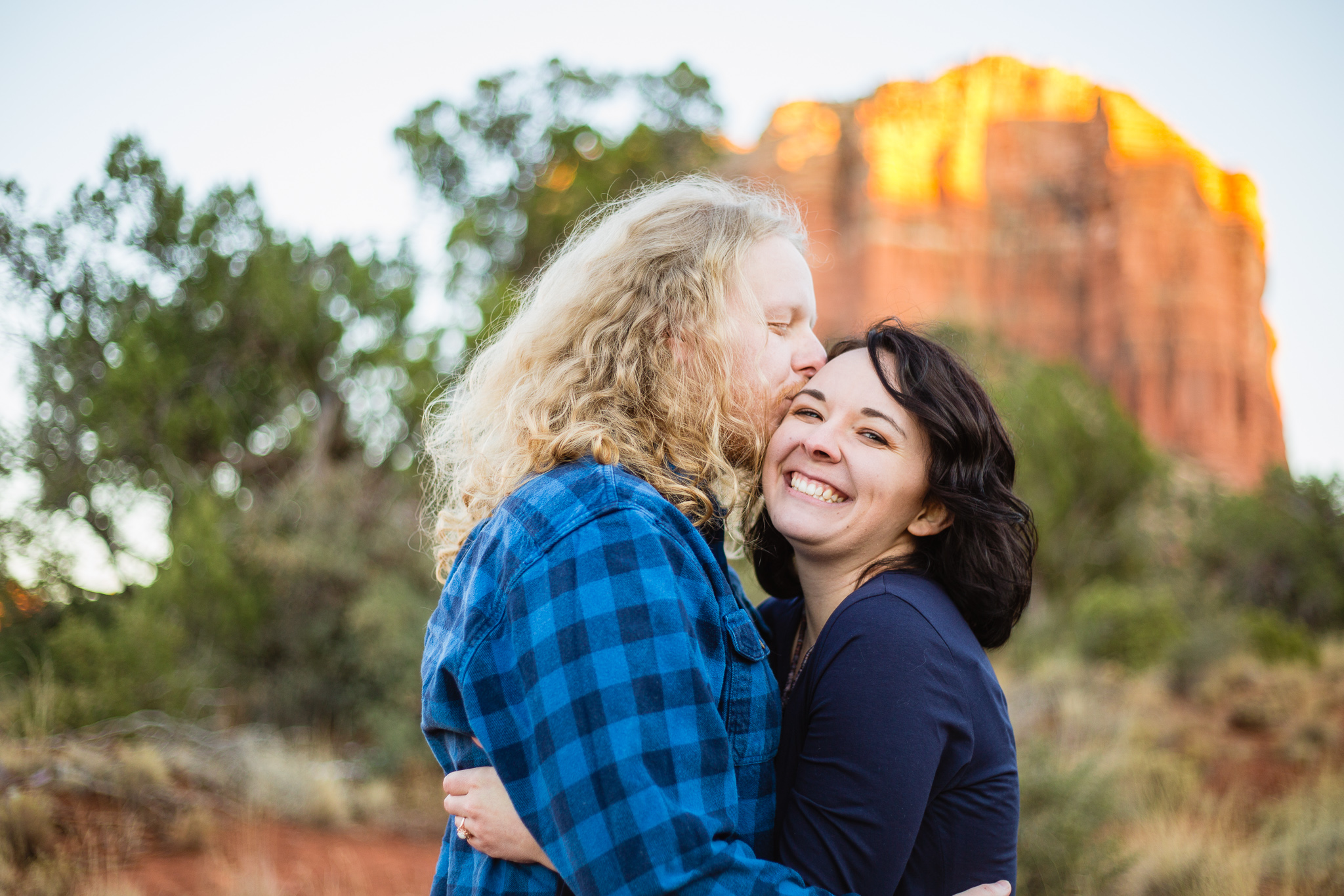 Fiance kissing the cheek of his wife to be during their Sedona engagement session by PMA Photography.