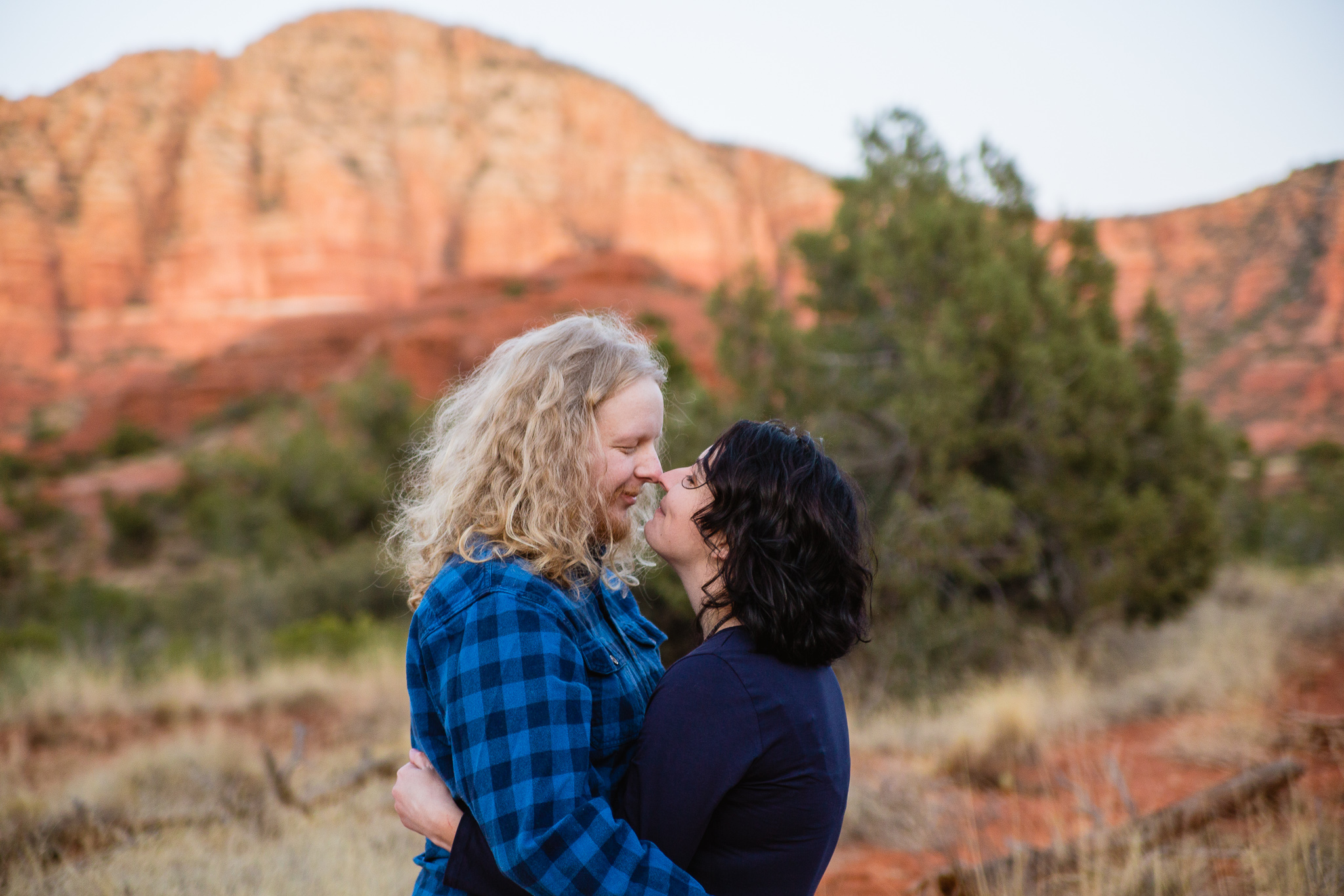 Couple looking at each other at Bell Rock Trail in Sedona Arizona Engagement Session Location.