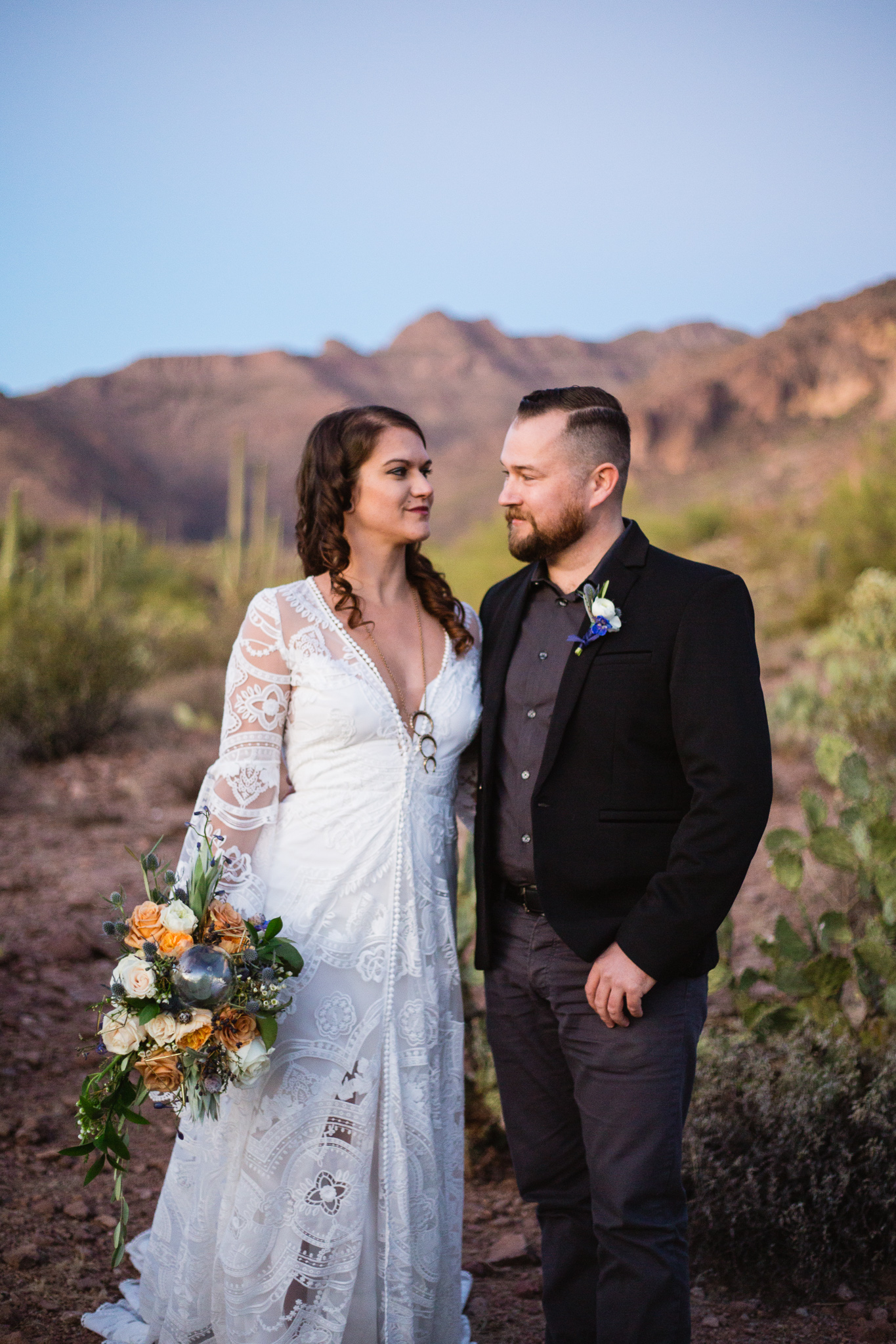 Witchy bohemian black white and gold inspired bride and groom at a Superstition Mountains styled wedding surrounded by the beauty of the desert.