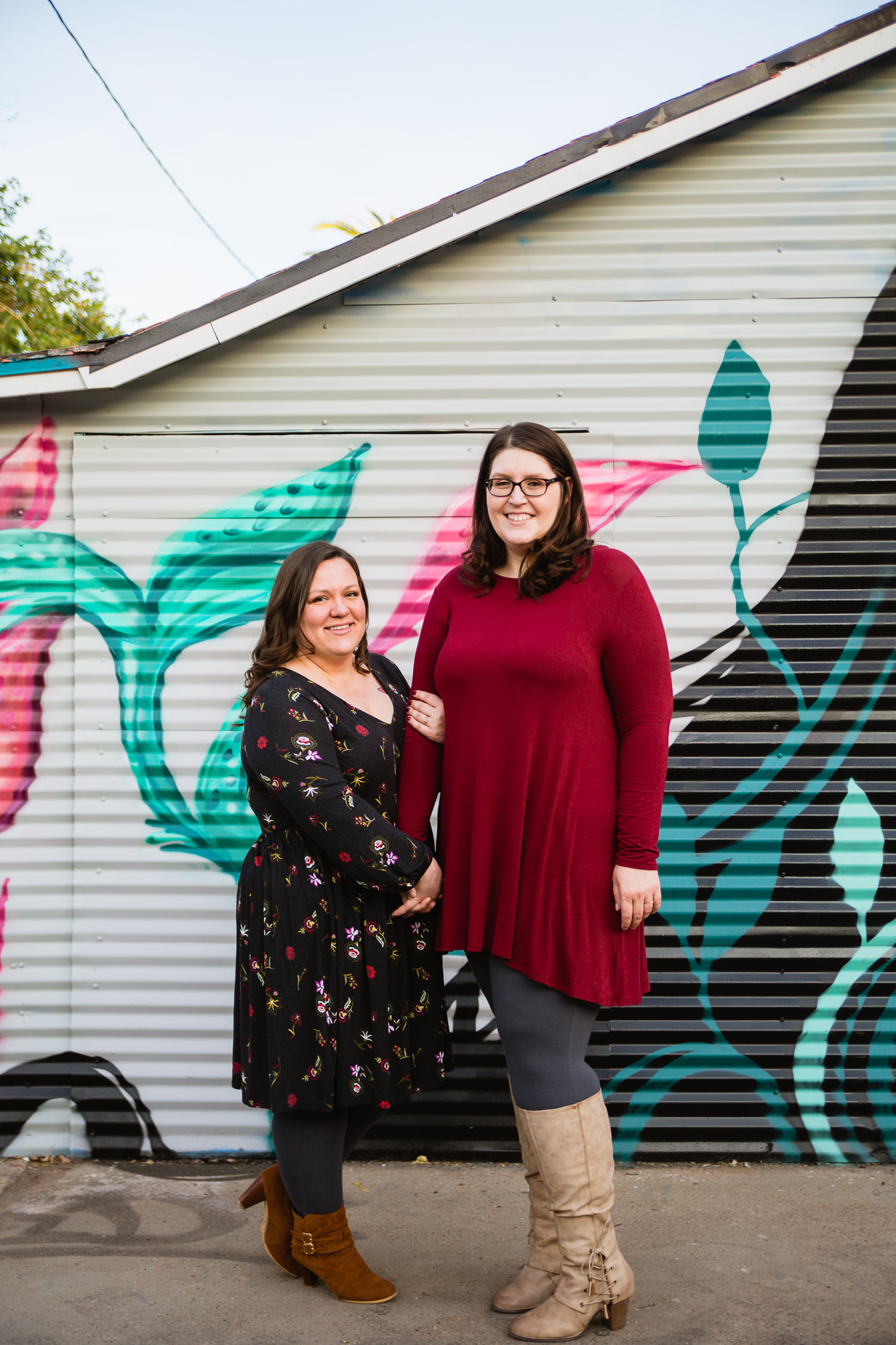 LGBT standing together in front of a mural for their engagement photography session in downtown Phoenix at Roosevelt Row.