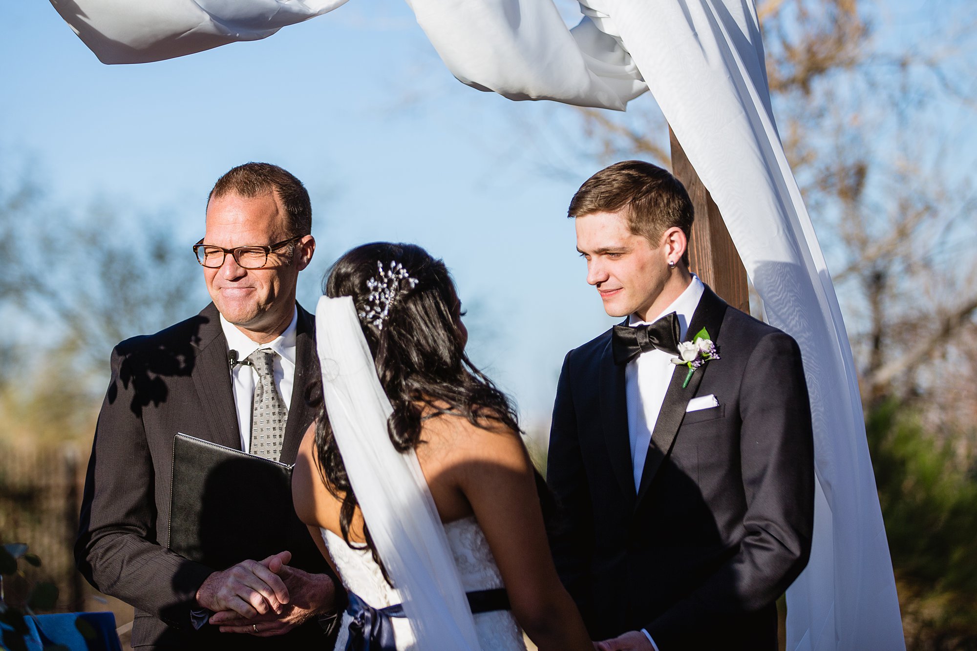 Groom looking at bride during wedding ceremony at the Rio Salado Audubon by Phoenix wedding photographers PMA Photography.
